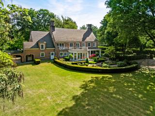 Deze architecturale Klassieke villa met oa. 5 à 6 slaapkamers en 3 badkamers op 5.233m² werd in 1981 gebouwd door architect Laporta, in opdracht van de huidige eigenaars. <br /><br />Indeling gelijkvloers:<br />Via de statige inkomhal met zijn mooie travertinvloer en grote trappartij betreden we deze klasse villa. Aan de rechter zijde treffen het zeer ruime kantoor, centraal de keuken en aan de linker zijde de woonkamer. Deze bestaat uit 3 ruime delen waaronder een leeshoek, een TV-hoek aan de openhaard en een eethoek met toegang tot het overdekte terras, de tuinkamer en aansluitend ook de zeer ruime keuken met ontbijthoek.<br />De keuken beschikt over een koele berging en brengt ons verder tot tot de wasplaats, de zeer ruime dubbele garage en de trap naar de kelderverdieping. <br />Via een overdekte doorgang naar de tuin komen we tot de 3e extra aangebouwde garage.<br /><br />Kelder:<br />Deze bestaat uit 2 verschillende delen en biedt veel bergruimte.<br /><br />Eerste verdieping:<br />De statige trap brengt ons tot de 1e verdieping, met hier de overloop op een mooie Brabo-parket, die ons tot de verschillende slaap- en woonvertrekken brengt.<br />De mastersuite bestaat uit een ruime dressing, een volledig vernieuwde badkamer met dubbele wastafel, een apart toilet en een strakke inloop-regen-douche en 2 slaapkamers of extra dressing.<br />De 3e en 4e slaapkamer delen een communicerende badkamer tussenin. De 5e kamer is momenteel ingericht als extra woonkamer met mooie kasteelhaard, bar, balkon en extra bergkamer.<br /><br />Tweede verdieping:<br />De vaste trap brengt ons tot de 2e verdieping met hier een kleine overloop. Deze brengt ons tot de 6e slaapkamer met eigen douchekamer. Het overige deel is een ontzettend ruime zolder (110 m²) met tal van mogelijkheden.<br /><br />Bijzonderheden:<br />- Uiterst rustige ligging in een doodlopende wijk, grenzend aan de Halse Bossen en Drijhoekbos; een natuurgebied van ca. 200 ha groot<br />- Mooi aangelegde en zonnige tuin met oa. mooi terras, vijverpartij, tennisterrein en tuinbergingen