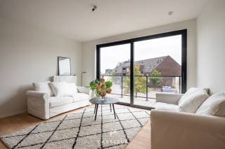 Wonen met comfort in het groen van Kluisbergen. Dit mooi afgewerkte nieuwbouwappartement van ca. 69m² (incl. terras) combineert eigentijdse architectuur met een kwalitatieve afwerking en unieke extra faciliteiten.<br /><br />Het appartement<br />Bij het binnentreden valt direct de warme sfeer op dankzij de prachtige parketvloer die is doorgetrokken in de leefruimte. De lichtrijke woonkamer staat in een open verbinding met de moderne, volledig geïnstalleerde keuken die is uitgerust met alle nodige comfort. Het appartement beschikt over één volwaardige, rustige slaapkamer, een strak afgewerkte badkamer met een comfortabele douche en een handige aparte berging. Buiten geniet u in alle rust op uw eigen privatieve terras.<br /><br />Unieke gemeenschappelijke faciliteiten<br />Wat dit gebouw extra aantrekkelijk maakt, zijn de uitstekende voorzieningen voor de bewoners. U krijgt toegang tot een mooi aangelegde gemeenschappelijke tuin met een petanquebaan, een gezellige ontmoetingszaal en een ruime veilige fietsenberging.<br /><br />Uitstekende ligging &amp; bereikbaarheid<br />Het appartement is prachtig gelegen in het hart van de Vlaamse Ardennen, op een boogscheut van het Kluisbos en bekende wandel- en fietsroutes zoals de Oude Kwaremont.<br /><br />Ondanks de rustige en groene omgeving is de bereikbaarheid uitstekend:<br />Verbindingen: Dankzij de nabijheid van de N60, N36 en N453 bereikt u vlot omliggende steden en gemeenten zoals Oudenaarde, Ronse, Avelgem, Maarkedal en Mont-de-l'Enclus. De snelweg E17 (oprit Waregem of Deerlijk) bevindt zich op slechts 15 tot 20 minuten rijden.<br /><br />Voorzieningen: Winkels voor de dagelijkse boodschappen (onder meer Delhaize, Spar en Carrefour Express), evenals lokale bakkers, slagers en apotheken bevinden zich in de directe nabijheid. Uitgebreider shoppen kan makkelijk in het nabijgelegen Oudenaarde of Ronse.<br /><br />Scholen: Verschillende basisscholen (zoals GBS De Start) en kinderopvangvoorzieningen liggen op wandel- of fietsafstand. Middelbare scholen in Ronse en Oudenaarde zijn eveneens vlot bereikbaar.<br /><br />Interesse in dit prachtige nieuwbouwappartement? Neem contact op voor meer informatie of om een bezoek in te plannen!<br /><br />Stedenbouw in aanvraag.