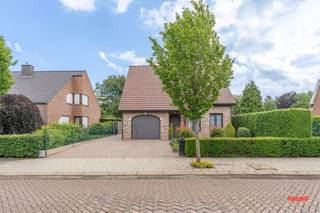 Zullen we meteen met een spoiler starten? Dit stulpje is jonger dan je denkt. <br /><br />Je zou op ’t eerste zicht misschien kunnen vermoeden dat ’t een jaren ’80-woning is, maar eigenlijk heeft deze nog maar net 30 kaarsjes uitgeblazen. En da’s natuurlijk piepjong, zegt deze 37-jarige makelaar.<br /><br />De woning zit misschien in een ietwat klassieker jasje, maar de structuur is dus wel prima. Geen asbest in de woning, geen renovatieplicht en de elektra is – op een paar puntjes na – in orde. Dus met een goeie lik verf en wat eigentijdse meubels ziet het er al helemaal anders uit.<br /><br />Indeling:<br />We vallen met de deur in huis, en stappen via de inkomhal de woonkamer in. Geen gedoe met overbodige muren, maar een open lay-out waar wonen, eten en koken samenkomt. De haard met gezellige schouwmantel zorgt voor extra sfeer. Heb je trouwens al opgemerkt dat de woning extreem netjes werd onderhouden, waardoor je dus echt een prima basis hebt om mee aan de slag te gaan?<br /><br />Zie je het op termijn toch nog iets groter? No problemo, wat dacht je van het opengooien van de keuken, waardoor je de veranda er ook bij kan trekken? De perfecte plek voor een grote keuken met eiland en zicht op je tuin, toch? <br /><br />Verder vind je beneden nog een eerste slaapkamer en badkamer, voorzien van een douche, bad, dubbele wastafel en een toilet. Future proof wonen: check!<br /><br />Helemaal aan de achterzijde zit tenslotte nog een grote bergplaats. De auto zet je droog te slapen in de inpandige garage, waar ook de aansluitingen voor wassen en drogen werden voorzien. <br /><br />Boven zijn 2 grote slaapkamers en een apart toilet, maarrr da’s nog maar het begin. Aan de achterzijde zit namelijk nog een grote, afgewerkte zolder die perfect ingericht kan worden als extra (slaap)kamer(s). <br /><br />De tuin is een allemansvriend: niet te groot, niet te klein en niet teveel gedoe. Vergis je trouwens niet: deze is groter dan je denkt, want achter de heg zijn nog wat tuinhokjes, compostbakken en een serre. <br /><br />En misschien nog dé grootste troef van dit gezellige stulpje: locatie, locatie, locatie! Je woont niet enkel in een rustige straat met fijne buren, maar ook voor kinderen is het de perfecte uitvalsbasis. Om de hoek van gezellige speelpleintjes, op fietsafstand van de school, openbaar vervoer en de dorpskern.