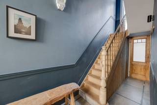 <p>In een rustige straat met enkel lokaal verkeer, vlak bij het Oud Justitiepaleis en de levendige Anselmostraat, bevindt zich dit charmante burgerhuis uit 1931. De buurt staat bekend om haar centrale ligging, groene parkeerzones, buurtwinkels en vlotte verbindingen met het centrum en de invalswegen.</p>
<p>Het pand werd circa zeven jaar geleden grondig gerenoveerd en combineert vandaag authentiek karakter met hedendaags comfort. Op het gelijkvloers bevindt zich een ruime slaapkamer met dressing en werkruimte, aangevuld met een recente badkamer met ligbad en douche. De eerste verdieping vormt het leefniveau met een zonnige woonkamer, eetruimte en een volledig uitgeruste keuken met AEG-toestellen. Op de tussenverdieping zorgt een gezellig terras samen met een apart toilet voor extra wooncomfort.</p>
<p>Op de tweede en derde verdieping bevinden zich telkens een ruime slaapkamer met ensuite badkamer en kitchenette, ideaal voor wie privacy of multifunctioneel gebruik wenst. Beide verdiepingen zijn voorzien van airconditioning. Het pand is volledig onderkelderd en biedt plaats aan een home office, wasruimte en extra berging. In 2021 werden tien zonnepanelen geplaatst met een nog terugdraaiende meter.</p>
<p>Dit pand is bijzonder geschikt voor gezinnen die ruim en centraal willen wonen, koppels die wonen en werken willen combineren, of investeerders op zoek naar een flexibel en rendabel stadspand.</p>
<p><strong>Interesse? Contacteer Listed voor een bezoek: +32 3 283 51 51.</strong></p>