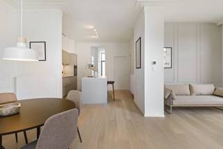 In een kleinschalig historisch hoekgebouw, dat met respect voor zijn karakter volledig werd gerenoveerd, bevindt zich op de eerste verdieping dit bijzonder aangename en lichtrijke appartement met twee slaapkamers.<br /><br />Bij het binnenkomen vallen meteen de royale plafondhoogte, de grote raampartijen en het open karakter van de leefruimte op. Vooraan geniet het appartement van een mooi en groen uitzicht over enkele karaktervolle burgerhuizen en het plein aan de Onze-Lieve-Vrouw-Geboortekerk. De grote ramen halen het daglicht rijkelijk naar binnen en versterken het ruimtelijke gevoel. Aansluitend aan de leefruimte bevindt zich bovendien een compact maar charmant sierterras.<br /><br />De open keuken vormt één geheel met de leefruimte en werd ingericht met een centraal eiland en alle nodige toestellen. Doorheen nagenoeg het volledige appartement werd een mooie parketvloer gelegd, met uitzondering van de vochtige ruimtes, wat zorgt voor een warme en stijlvolle uitstraling.<br /><br />Via de nachthal bereiken we de ruime badkamer met inloopdouche, een afzonderlijk toilet en twee volwaardige slaapkamers van ca. 12,5 m² en 9 m². Beide slaapkamers bevinden zich aan de rustige zijde van de d’Urselstraat. Vanuit de nachthal is er bovendien toegang tot een aangename extra buitenruimte (+-10m²) om in alle rust van de buitenlucht te genieten.<br /><br />Ook praktisch heeft dit appartement heel wat te bieden. In de kelderverdieping beschikt het over een private kelderberging en in de gemeenschappelijke inkomhal is een fietsenberging voorzien.<br /><br />Een bijzonder geslaagd appartement waar historische charme, licht, ruimte en hedendaags wooncomfort mooi samenkomen.<br />Bovendien superenergiezuinig: EPC label A = 42kwh/m²! alsook conforme elektriciteit én individuele zonnepanelen.<br /><br />Heeft u interesse in deze woning? Neem dan contact met het kantoor van VB Vastgoed Hoboken op het nummer 03 337 50 70 of via <span>info@vbvastgoed.be</span><br /> 