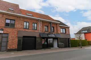 Ruime gezinswoning, tuin en vergunning voor een nieuw atelier in Veldegem<br /><br />Wonen en ondernemen op één adres, met ruimte om uw zaak verder uit te bouwen. Dit handelspand aan de Koning Albertstraat in Veldegem combineert een brede, opvallende gevel met een verzorgd woongedeelte, vijf slaapkamers en een tuin. De eigendom ligt op een perceel van 438 m²en beschikt over een toegekende omgevingsvergunning voor de vernieuwing en uitbreiding van de slagerij.<br /><br />Aan de straatzijde bevindt zich de ingerichte winkelruimte met een lange koeltoonbank. Achteraan sluiten de werkruimtes en professionele koelcellen aan, aangevuld met een personeelsruimte met kitchenette. De commerciële ligging en de brede voorgevel geven uw zaak een goede zichtbaarheid.<br /><br />Vergunde uitbreiding met nieuw atelier<br /><br />Op 7 mei 2026 verleende de deputatie een omgevingsvergunning onder voorwaarden. Het goedgekeurde ontwerp voorziet in:<br /><br />* De sloop van het bestaande slagersatelier van 113,14 m² en de bouw van een nieuw atelier van 187,43 m².<br />* Een nieuwe indeling met koelcellen, opslag, bureauruimte en verwerkingsruimtes.<br />* De interne verbouwing van de bestaande winkel.<br />* Een vernieuwde gevelafwerking met gekaleide gevelstenen, zwart aluminium schrijnwerk en houten accenten.<br />* De heraanleg van de buitenruimte met terras, gazon en een voorziening voor regenwaterinfiltratie.<br /><br />Ook het woongedeelte heeft heel wat te bieden. De lichtrijke leefruimte combineert een gezellige zithoek met een ruime eetplaats. Warme tinten en een verzorgde afwerking zorgen voor een huiselijke sfeer. De uitgeruste keuken beschikt over een lang werkblad, veel kastruimte, ingebouwde toestellen en een praktische ontbijtbar.<br /><br />Met vijf volwaardige slaapkamers, een badkamer met ligbad, stoomdouche en dubbele wastafel, een wasplaats en zolderberging is er voldoende ruimte voor het gezin. De ruime inkomhal biedt bovendien plaats voor fietsen.<br /><br />In de huidige inrichting beschikt de eigendom over een afgeschermd terras en een omsloten tuin. Een garage, zonnepanelen en een warmtepomp vervolledigen het geheel. De eigendom werd grondig gerenoveerd in 2004.<br /><br />Dankzij de vlotte verbindingen naar de invalswegen en autosnelweg is het pand goed bereikbaar voor zowel bewoners als klanten.<br /><br />Meer weten over de eigendom of de vergunde plannen? Contacteer Simon via 0498/123.708 of simon@vicusvastgoed.be en plan uw bezoek.
