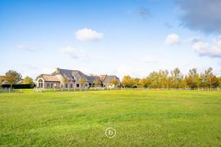 Verscholen in een groen en privatief domein van 1,5 ha bevindt zich dit indrukwekkende landhuis met een bewoonbare oppervlakte van maar liefst 605 m2. Een residentie waar ruimte, rust en karakter samenkomen te midden van de uitgestrekte polders van Middelkerke.<br /><br />Vanaf het moment dat u de eigendom bereikt via de oprijlaan wordt duidelijk dat dit geen alledaagse woning is. De ontvangstruimtes ademen karakter en werden ingericht met kwalitatief maatwerk waardoor een warme en stijlvolle leefomgeving ontstaat. De charmante orangerie of bibliotheek biedt een unieke plek om te genieten van de vergezichten over het eigen domein. De landelijke leefkeuken vormt het hart van de woning en sluit naadloos aan op de verschillende leefruimtes. Royale raampartijen brengen het omliggende landschap tot diep in de woning en zorgen voor een voortdurende verbinding met het buitenleven. <br /><br />De verdieping werd ingericht met een royale mastersuite, aanvullende slaapkamers, meerdere badkamers en diverse dressingmogelijkheden. Met een bewoonbare oppervlakte van 605 m2 en een bijzonder flexibele indeling biedt deze eigendom tal van mogelijkheden voor uiteenlopende woonconcepten. De inrichting van een volwaardige kangoeroewoning behoort hier zonder meer tot de mogelijkheden, waardoor verschillende generaties comfortabel kunnen samenleven met behoud van hun privacy.<br /><br />Op het domein bevindt zich bovendien een bijgebouw van 94m2 dat vandaag dienst doet als garage voor meerdere wagens. Voor paardenliefhebbers zijn er drie paardenboxen en een aangelegde piste aanwezig waardoor het geheel perfect aansluit bij een landelijke levensstijl.<br /><br />Dit is een eigendom voor wie op zoek is naar ruimte in haar meest luxueuze vorm.