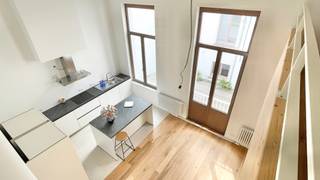 <p>In het iconische gebouw ‘RR33’, gelegen op de Koningstraat ter hoogte van het Warandepark, op de 2e verdieping aan de achterzijde, stellen wij u deze prachtige lichtrijke duplex appartement van meer dan 140m2 voor. Het pand biedt u: een inkomhal, een ruime leefruimte met op maat gemaakte open keuken, een bureau met aparte ingang, een nachthal, een afzonderlijk toilet, een waskamer, twee slaapkamers (14 – 12m2) met elk een en-suite badkamer, een bureau in mezzanine (plafondhoogte 2,5m) en een ondergronds een privatieve kelder. Volledig nieuw en eerste bewoning. Dubbel glas. Elektriciteit conform. Beschikbaar bij akte. Op een excellente locatie nabij het openbaar vervoer, eveneens vlot bereikbaar met de auto en nabij winkels. Zal u bekoren door zijn lichtinval, rustige ligging langs de achterzijde en lichtinval. Zeker een bezoek waard!</p>