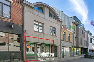 Deze kwalitatief verhuurde investeringseigendom is uitstekend gelegen in het hart van Asse, in de Nieuwstraat. Dankzij de centrale ligging geniet het pand van veel passage, een uitstekende zichtbaarheid en parking voor de deur. Het commerciële gelijkvloers is momenteel verhuurd aan het gekende GLOWI (Poetsbureau) via een handelshuurovereenkomst die gestart is op 1 augustus 2017 en recent werd hernieuwd vanaf 1 augustus 2026. De actuele maandelijkse huurprijs bedraagt € 1.668,84, aangevuld met € 50 vaste kosten per maand. Het handelsgelijkvloers beschikt over een oppervlakte van circa 170 m² en is bovendien voorzien van een ruime kelder van circa 98 m². De ligging is bijzonder commercieel interessant, met onder andere Leonidas, AZORG en Konvert Interim in de onmiddellijke omgeving. Het pand beschikt over een EPC-label C en de elektrische installatie is conform. Daarnaast werd het dak extra geïsoleerd, werd de oude ventilatie-unit verwijderd en zijn alle voorzieningen aanwezig om zonnepanelen te plaatsen. Het pand is bovendien asbestveilig. Een interessante opportuniteit voor investeerders die op zoek zijn naar een goed gelegen, verhuurde commerciële eigendom met een stabiele huurstroom in het centrum van Asse. Interesse of wenst u meer informatie of een bezoek ter plaatse? Contacteer ons via info@immodelestre.be of 054 33 62 52. Meer informatie vindt u op www.immodelestre.be.