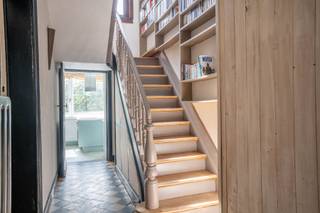 Century21ImmoNero stel voor, deze bijzonder ruime (237m²) en stijlvolle karakter woning die u zal verleiden door zijn ongeëvenaarde charme en vele authentieke elementen, uitstekend gelegen op een paar honderd meter van treinstation en centrum en vlakbij winkels en school en op wandelafstand van het Zoniënwoud. De woning, die volledig onderkelderd is bestaat uit: Gelijkvloers: mooie inkom met trap, afzonderlijke vestiaire ruimte met ingemaakte kasten en WC,living 35m², zeer lumineuze keuken van 12m² en een garage met elektrische sectionale poort. Verdiep: mooie ouderkamer met een ensuite badkamer met bad en douche, 2 kamers waarvan 1 nog af te werken. Zolder: studio met ingerichte keuken, badkamer met WC, living met mezannine, en 2 kamers, waarvan 1 nog af te werken. In de tuin vindt U verschillende sfeervolle terrassen en een ruime berging. De gas condensatie ketel dateert van 2022.Beschikbaar 3 maand na ondertekening Akte. MEER INFO: www.groenendaalsesteenweg67.be