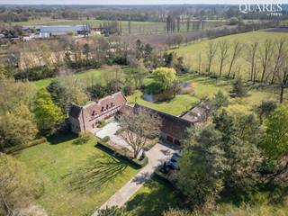 Quares - TREVI Groep presenteert :<br />Deze 15de-16de -eeuwse herenhoeve, gekend als “Hooghuis”, beschikt over een combinatie van authentieke elementen en luxe afwerking. De herenhoeve is vastgesteld bouwkundig erfgoed. Doorheen de jaren is er gerenoveerd met respect voor de landelijke architectuur, èn rijkelijke geschiedenis, dit in combinatie met hedendaagse luxe. De lange oprijlaan geeft u toegang tot het prachtige domein. In totaal beschikt u over 27.831m² grondoppervlak.<br /><br />Op de gelijkvloers treft u volgende indeling: U komt binnen via de ontvangstkamer en “ridderzaal”. De keuken, in volle eik en natuursteen, is uitgerust met de nodige toestellen. Praktisch is de bijkeuken en bergruimte. De living heeft uitzicht op het prachtige parkdomein en vijver. Er is heel wat maatwerk terug te vinden doorheen de woonst. Dit onder de vorm van: ingemaakte kasten, restauratie authentieke elementen, en natuursteen.<br />De slaapverdieping biedt plaats voor 5 slaapkamers en meerdere badkamers. De master bedroom is uitgerust met een walk-in dressing, een luxueuze en-suite badkamer èn lift.<br /><br />Naast de riante garage, voor meerdere wagens, is er een ruime feestzaal/receptieruimte voorzien. Ideaal om gasten te ontvangen. In het bijgebouw is tot slot een welness voorzien met stoombad, sauna, whirlpool, binnenzwembad en fitness. Benieuwd naar de mogelijkheden van deze eigendom? Contacteer ons gerust voor meer informatie of het inplannen van een plaats bezoek.