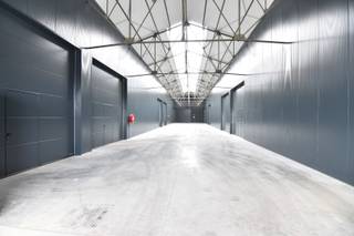 Instapklare, geïsoleerde OPSLAGRUIMTE (200 m²), hoge sectionaalpoort en gemeenschappelijke PARKEERPLAATSEN op ambachtelijke zone te...