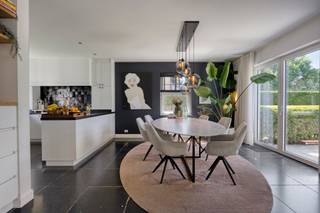 <p><strong>Wil jij wonen in dit prachtig huis waar luxe en natuur elkaar ontmoeten? Welkom in deze oase van rust in Kapellen. </strong><br /><br />Een eerste indruk maak je maar één keer. En bij deze villa in de Oude Galgenstraat zit die indruk direct goed. Vergeet de standaard woningen, dit is een plek voor wie begrijpt dat kwaliteit in de details zit. Van de natuurstenen vloeren tot de directe toegang tot het achterliggende Mastenbos, dit is wonen op topniveau en aan elk detail is gedacht. <br /><br /><strong>Bij het binnenstappen in de inkomhal voel je het meteen: dit huis ademt sfeer.</strong> De royale living en eetkamer lopen naadloos over in de open veranda. Dankzij de grote raampartijen haal je het groen van de tuin letterlijk naar binnen. Zowel in de zomer als in de winter een plek om tot rust te komen. <br /><br />De open keuken, uitgerust met een granieten werkblad, nieuw gasvuur en hoogwaardige toestellen (inclusief splinternieuwe Quooker kraan met gefilterd- en bruiswater), is de plek waar herinneringen worden gemaakt aan de keukentafel.<br /><br />Wat deze woning nog onderscheidt, is de multifunctionele ruimte op het gelijkvloers. Oorspronkelijk een garage, nu een stijlvol bureau of praktijkruimte met ingemaakte kasten. Of je nu een vrij beroep uitoefent of een extra slaapkamer op het gelijkvloers wenst: de flexibiliteit is hier een enorme troef.<br /><br />Op de verdiepingen is er aan ruimte geen gebrek. De eerste verdieping herbergt drie ruime slaapkamers op parket, waaronder de masterbedroom met een ensuite badkamer (inloopdouche en dubbel marmeren lavabomeubel). Voor de kinderen of gasten is er een tweede, praktisch ingerichte badkamer.<br /><br />De vaste trap naar de tweede verdieping onthult nog eens twee grote slaapkamers en een overloop. Met in totaal vijf tot zes slaapkamers is dit de ideale gezinswoning.<br /><br /><strong>Laten we eerlijk zijn: de buitenruimte is waar je echt verliefd op wordt. Het perceel van ca. 2.028 m² is een paradijs voor rustzoekers. </strong>De tuin voelt als een vakantie bestemming, elke minuut van de dag kan je hier genieten van rust en zon. Het monobloc zwembad met plage, aangelegd in 2020, nodigt uit tot een frisse duik, terwijl het eiken poolhouse met buitenkeuken en overdekt terras de perfecte setting is voor BBQ’s en lange avonden met vrienden.<br /><br />Hier is ook een in 2025 volledig afgewerkte badkamer met douche, toilet en handenwasser. Gasten hoeven dus niet naar binnen van aan het zwembad. <br /><br />En die poort achteraan? Die geeft je direct toegang tot een padje naar het Mastenbos voor een ochtendwandeling in de natuur. Achterin de tuin is er de mogelijkheid tot het houden van schaapjes of paarden. <br /><br />In de wereld van vandaag is energiezuinigheid geen luxe meer, maar een must. Met een EPC-label B (145 kWh/m²), 18 zonnepanelen, een thuisbatterij en een laadpaal voor je elektrische wagen, ben je hier volledig ontzorgd. Het schrijnwerk in hout/aluminium en de verwarming op gas zorgen voor een optimaal binnenklimaat.<br /><br /><strong>Waarom dit jouw volgende thuis is? </strong><br /><br />Locatie: Residentieel en groen, met een vlotte verbinding naar Antwerpen.<br /><br />Afwerking: Hoogwaardige materialen zoals marmer, blauwe hardsteen en parket.<br /><br />Techniek: Alarmsysteem met camera’s, waterontharder en grondwaterput. <br /><br />Privacy: Geen inkijk en een tuin die grenst aan het bos.<br /><br />Woningen met dit afwerkingsniveau en deze energieprestaties blijven niet lang op de markt. Het is de perfecte match voor wie luxe wil combineren met de warmte van een echt gezinshuis met een lage onderhoudskost. Deze woning is tot in de puntjes afgewerkt en instapklaar. <br /><br />Kom eerst vooral zelf de sfeer proeven. Dit is een kans die je niet wilt laten liggen!<br /><br /><strong>Bezoekmoment: zondag 6 september tussen 14u en 17u (na afspraak)</strong><br /><br />Voor meer info of een bezoek te plannen surf naar www.oudegalgenstraat33.be!</p>