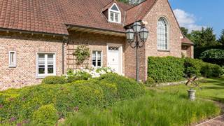 Deze uitzonderlijke villa is gelegen op een schitterende kavel van 2.681 m². De locatie van deze villa is uniek te noemen. Ze is uitstekend gelegen in het groen, op fietsafstand van het centrum. Er is een vlotte verbinding naar de op- en afritten van E34 (Turnhout-Eindhoven). Aangrenzend aan het Natura2000 Turnhouts vennengebied. Scholen, winkels, etc. bevinden zich in de onmiddellijke nabijheid. <br /><br />De villa is ideaal voor een kroostrijk gezin op zoek naar ruimte en gezelligheid. Deze villa heeft het allemaal: 5 slaapkamers, 2 badkamers, diverse leef- en zitruimten, een dubbele inpandige garage en een prachtige aangelegde tuin. De afwerking van de gehele villa is zeer kwalitatief met oog voor detail.<br /><br />Gelijkvloers: <br />De gezellige voortuin met voldoende parkeergelegenheid brengt u tot de voordeur van deze riante villa. Bij het betreden van de inkomhal ervaart u onmiddellijk de gezellige sfeer. De inkomhal reikt tot de eerste verdieping en vormt het centrale hart van deze villa. <br /><br />De deuren bieden vanuit deze hal toegang tot de verschillende ruimten. Zo treft u een gastentoilet met tussenruimte, geschikt als vestiaire. Aan de rechterkant bevinden zich de leefruimten, met o.a. een schitterende eetkamer en twee gezellige zithoeken waarvan 1 met grote open haard. Deze leefruimten beschikken allen over een massief eiken parketvloer, grote raampartijen met mooi zicht naar de tuin.<br /><br />Vanuit de centrale inkomhal hebt u toegang tot de riante woonkeuken, compleet ingericht met toestellen, gezellige eethoek en voldoende kastruimte. <br /><br />Verder bevindt zich op het gelijkvloers een dubbele inpandige garage, momenteel ingericht als multifunctionele ruimte met sauna en veel opslagmogelijkheden. Inclusief extra werkplaats en aparte technische ruimte. Ideaal voor ontspanning, hobby's en praktische toepassingen. <br /><br />Eerste verdieping: <br />De stijlvolle trap brengt u vanuit de centrale inkomhal naar de bovenliggende verdieping. De ruime overloop geeft toegang tot de sfeervolle mastersuite met eigen badkamer. De badkamer is voorzien van een ligbad, douche, toilet en dubbele wastafel in meubel. <br />Verder nog vier ruime slaapkamers met veel lichtinval. De tweede badkamer op deze verdieping is voorzien van ligbad en dubbele lavabo in meubel. <br />Verder op deze verdieping treft u een extra gezellige zithoek, ook rechtstreeks te bereiken via de tv-hoek op de gelijkvloerse verdieping. <br /><br />Tweede verdieping:<br />Via een vlizotrap is de ruime zolder te bereiken. Deze praktische zolder biedt tal van mogelijkheden voor extra opslag. <br /><br />Sfeervolle wijnkelder:<br />Voor de echte wijnliefhebber is deze woning voorzien van een authentieke, sfeervolle wijnkelder. Perfect voor het bewaren en presenteren van uw favoriete flessen. Een uniek en karaktervol element dat deze woning compleet maakt. <br /><br />Tuin: <br />De oost gerichte tuin is schitterend aangelegd, geniet van bomen, veel groen, absolute rust en privacy en is voorzien van diverse terrassen. Verder nog een praktische tuinberging en een ruime overkapping/terras aanwezig. De tuin is volledig omheind en vooraan afgesloten met een automatische toegangspoort. <br /><br />Bijzonderheden: <br />- Pareltje voor wie op zoek is naar luxe en ruimte in een landelijke en rustige omgeving, op een boogscheut van de Nederlandse grens. <br />- Verwarming op stookolie d.m.v. radiatoren <br />- Bijzonder hoogwaardige afwerking <br />- Airco's <br />- 28 zonnepanelen <br />- Voorzien van professioneel alarmsysteem en camerabewaking<br />- De woning heeft een eigen drinkwatervoorziening d.m.v. een geboord put (210m) <br /><br />Kortom, een villa zoals u er geen 2de zult vinden qua architectuur, afwerking en vooral wat sfeer en belevingswaarde betreft!