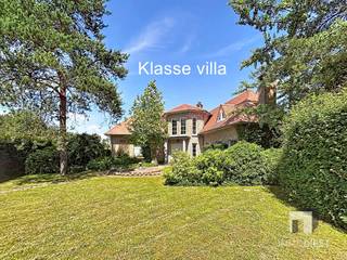 <p><span>Deze klasse villa gelegen op de rand van het natuurgebied Gerhagen op 2km van het centrum van Tessenderlo is gelegen op een grondoppervlak van 1529 m². </span></p><p><span>Deze woning biedt een indrukwekkende bewoonbare oppervlakte van 332 m² en is voorzien van 4 ruime slaapkamers (5 mogelijk) en 2 stijlvolle badkamers, perfect voor een groot gezin of om gasten te ontvangen.</span></p><p><span> </span></p><p><span>Bij aankomst wordt u begroet door een uitnodigende oprijlaan en een prachtig aangelegde tuin die privacy en rust verzekeren. De voortuin is een groen paradijs en biedt een idyllische eerste indruk.</span></p><p><span> </span></p><p><span>Binnenin vindt u een royale inkomhal die overloopt in een ruime en elegante leefruimte. Deze ruimte is voorzien van grote ramen die voor een overvloed aan natuurlijk licht zorgen. De leefruimte is smaakvol ingericht en leidt naar een aparte eetkamer, ideaal voor feestelijke diners.</span></p><p><span> </span></p><p><span>De keuken is modern ingericht en uitgerust met alle nodige toestellen, wat koken tot een plezier maakt. Van hieruit heeft u een prachtig uitzicht op de tuin, die perfect is voor buiten dineren met een stijlvolle patio gevoel.</span></p><p><span> </span></p><p><span>De eerste verdieping bevindt een luxueuze masterbedroom met een eigen dressing. De overige slaapkamers zijn ruim en veelzijdig in gebruik, met een slaapkamer die uitkomt op een charmant terras, perfect voor het ontwaken op een zomerochtend.</span></p><p><span> </span></p><p><span>Extra voorzieningen zijn onder andere twee ruime garages, ideaal voor autoliefhebbers of extra opslag. De kelder is droog en netjes afgewerkt, wat voor extra opslagruimte zorgt.</span></p><p><span> </span></p><p><span>Dit huis belichaamt stijl en comfort en is omgeven door een weelderige tuin, wat bijdraagt aan de landelijke charme. Een pareltje voor wie op zoek is naar een mix van luxe en sereniteit. Mis deze unieke kans niet!</span></p><p><span> </span></p><p><span>TIP in drie stappen naar een EPC met label B :</span></p><p><span>- Plaats zonnepanelen + 20 cm MW + warmtepomp =  EPC label B</span></p><p><span> </span></p><p><span>Bel Immo Diest 013/31.25.22, wij helpen u verder met de glimlach.</span></p>