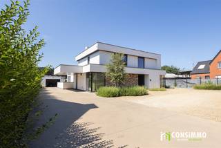 Deze <strong>exclusieve, moderne villa</strong> combineert een verfijnde architectuur met een bijzonder hoog niveau van wooncomfort en energiezuinigheid. Met een vloeroppervlakte van maar liefst <strong>248 m²</strong>, een royaal perceel van <strong>18a 11ca</strong> en een uitzonderlijk <strong>EPC-label A met een energiescore van slechts 5 kWh/m² per jaar</strong>, werd hier duidelijk gekozen voor ruimte, kwaliteit en duurzaamheid. De hoogwaardige afwerking, maatwerkkasten en doordachte indeling trekken die lijn doorheen de volledige woning.<br /><br /><strong>Indeling</strong><br />De royale inkomhal met <strong>indrukwekkende vide</strong> zet meteen de toon. Ingebouwde vestiairekasten zorgen voor een strakke afwerking en via een stijlvolle stalen deur bereikt u de lichtrijke leefruimte. In de living treffen we ook een gezellige doorkijkhaard, met zicht op de keuken. Verder treffen we een bijkomend hoekje dat zich uitstekend leent als bureau, lees- of speelhoek. Op het gelijkvloers bevindt zich tevens een afzonderlijk bureau en gastentoilet.<br />Aansluitend vinden we de eetkamer en de hoogwaardig afgewerkte keuken, uitgevoerd in kwalitatieve materialen en voorzien van alle moderne inbouwtoestellen. De aangrenzende berging met maatwerkkasten biedt volop praktische opslagruimte.<br /><br />Op de verdieping bevinden zich <strong>drie ruime slaapkamers</strong>. De masterbedroom beschikt over een eigen dressing, terwijl de twee overige slaapkamers uitgerust zijn met inbouwkasten. Iedere slaapkamer beschikt bovendien over een eigen <strong>airco-warmtepomp voor zowel koeling als verwarming</strong>.<br />Ook de badkamer sluit perfect aan bij het luxueuze karakter van de woning en werd hoogwaardig afgewerkt met een ruime inloopdouche, ligbad, dubbele lavabo en toilet. Een afzonderlijke linnenkamer met maatwerkkasten en aansluitingen voor wasmachine en droogkast vervolledigt deze verdieping.<br /><br />De functionele kelder biedt nog heel wat bijkomende mogelijkheden en kan worden ingericht als <strong>fitnessruimte, hobbykamer, speelruimte of extra opslagruimte</strong>. Dankzij de afzonderlijke toegang langs buiten is deze ruimte bovendien bijzonder praktisch, wat het ook geschikt maakt om het in te richten als <strong>kantoor </strong>of <strong>praktijkruimte</strong>.<br /><br />Vanuit zowel de leefruimte als de keuken bereikt u het <strong>overdekte terras en de bijzonder ruime tuin</strong>. Achteraan bevindt zich een garage met bijkomende opslagruimte. Aan de voorzijde biedt de royale oprit met een architecturale <strong>zwevende carport</strong> plaats aan meerdere wagens en bezoekers. Het perceel wordt afgesloten met een hoogwaardig afgewerkte, automatisch bedienbare poort.<br /><br /><strong>Technische informatie</strong><br />Ook energetisch bevindt deze villa zich op een uitzonderlijk niveau. Met een <strong>EPC-label A en een energiescore van amper 5 kWh/m² per jaar</strong> benadert de woning een bijna-energieneutraal niveau. De woning is doorgedreven geïsoleerd, bovenop de geldende vereisten, en wordt verwarmd via vloerverwarming op aardgas. Daarnaast zijn er <strong>24 zonnepanelen met een totaal piekvermogen van circa 8 kWp</strong>, gecombineerd met een thuisbatterij. Een ventilatiesysteem type D zorgt voor een continue en gecontroleerde luchtverversing. De aluminium ramen met superisolerende beglazing dragen verder bij aan het uitstekende wooncomfort.<br /><br /><strong>Buurtinformatie</strong><br />De villa bevindt zich in een <strong>residentiële omgeving van Genk waar rust, ruimte en dagelijks comfort mooi samenkomen</strong>. Op wandelafstand vindt u onder meer openbaar vervoer en een kleuter- en basisschool, terwijl supermarkten, bakkers, apotheken, medische voorzieningen en andere dagelijkse faciliteiten vlot bereikbaar zijn. Ook het <strong>Ziekenhuis Oost-Limburg</strong> bevindt zich in de nabije omgeving en <strong>Genk-Centrum ligt op amper vijf minuten rijden</strong>.<br />Wie graag in het groen vertoeft, vindt met onder meer <strong>Kattevennen</strong> en de omliggende natuur tal van mogelijkheden om te wandelen, sporten en ontspannen. De ruime, groene omgeving is bovendien bijzonder aangenaam voor gezinnen en dierenliefhebbers. Tegelijk wordt er verder geïnvesteerd in de omgeving, wat bijdraagt aan de verdere kwalitatieve ontwikkeling van de buurt.<br /><br />Een villa voor wie geen keuze wil maken tussen <strong>architectuur, ruimte, luxe en uitzonderlijke energiezuinigheid</strong>.<br />Bent u op zoek naar een <strong>exclusieve villa met een hoogwaardige afwerking, een riante tuin en uitzonderlijke energetische prestaties</strong>? Contacteer ons via <strong>089 69 30 01</strong> of <strong>info@consimmo.be</strong> voor meer informatie of een bezoek ter plaatse. <strong>Bekijk ook de virtuele tour op onze website </strong><strong>www.consimmo.be</strong><strong>.</strong>