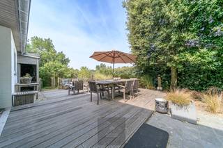 Op een uitzonderlijke locatie in Groenendijk-Oostduinkerke, op de grens met Nieuwpoort-Bad en op slechts 400 meter van het strand, bevindt zich deze charmante Mi Casa-woning op een prachtig perceel van maar liefst 1.271 m². De combinatie van de unieke ligging, de warme houtskeletbouw en de groene, zonnige tuin creëert een heerlijk beach house-gevoel waar rust, ruimte en de kust naadloos samenkomen.<br />De woning, gebouwd in 2001, verwelkomt u via een ruime inkomhal met apart gastentoilet. De lichtrijke woonkamer met gezellige haardcassette vormt het hart van de woning en geniet dankzij de grote raampartijen van een prachtig zicht op het zonnige terras, de fraai aangelegde tuin en de sfeervolle vijver. Aansluitend bevindt zich de eetplaats en de open keuken, die samen zorgen voor een aangename en open leefomgeving.<br />Op het gelijkvloers beschikt de woning verder over een ruime garage met praktische kelder, een carport en een afzonderlijke tuinberging.<br />De bovenverdieping omvat drie volwaardige slaapkamers, waaronder een royale master bedroom uitgerust met een airco voor optimaal comfort. De badkamer is ingericht met een dubbele wastafel, een ligbad en een afzonderlijke douche. Daarnaast bevindt zich op deze verdieping nog een apart toilet en een gedeeltelijke zolderberging die extra opbergruimte biedt.<br />Ook op technisch vlak scoort deze woning bijzonder goed. Zo is ze uitgerust met een regenwaterput van 10.000 liter en zonnepanelen, wat bijdraagt aan een duurzame en energiezuinige woonervaring.<br />Deze authentieke Mi Casa-woning in houtskeletbouw straalt warmte en karakter uit en vormt een zeldzame opportuniteit voor wie op zoek is naar een instapklare gezinswoning of een tweede verblijfplaats op wandelafstand van zee. Dankzij de uitzonderlijke ligging tussen de duinen, het strand, Groenendijk en Nieuwpoort-Bad geniet u hier elke dag van een permanent vakantiegevoel aan de Belgische kust. EPC: 211 kWh/m². Vraagprijs: 795000€