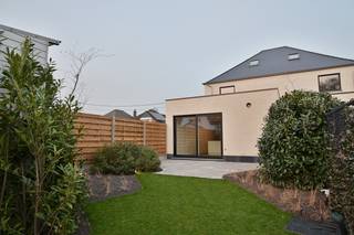 Deze volledig gerenoveerde woning combineert het karakter van een charmante woning uit de jaren ’50 met het comfort en de energiezuinigheid van een hedendaagse woning. Gelegen in een rustige en groene omgeving geniet u hier van een aangename woonomgeving met een vlotte verbinding naar omliggende gemeenten, winkels, scholen en belangrijke invalswegen. Dankzij de grondige renovatie behaalt de woning een energiezuinig EPC-label A en kan de aankoop bovendien gebeuren aan slechts 2% registratierechten.<br /><br />Bij het binnenkomen betreedt u de inkomhal met gastentoilet. Vanuit de inkomhal leidt een stijlvolle glazen deur naar de lichtrijke woonkamer. Een gang met praktische ingemaakte kasten verbindt de woonkamer met de keuken en aangrenzende eetplaats en zorgt voor een logische en functionele indeling. De moderne keuken is volledig uitgerust met kwalitatieve inbouwtoestellen, waaronder een koelkast, diepvries, combi-oven, vaatwasmachine, spoelbak en een inductiekookplaat met geïntegreerde dampkap. Verder bevindt zich op het gelijkvloers nog een technische ruimte met aansluitingen voor wasmachine en droogkast en de warmtepomp.<br /><br />Op de eerste verdieping bevinden zich twee slaapkamers, waarvan één voorzien van ingemaakte kasten, en een moderne badkamer uitgerust met inloopdouche, lavabo en toilet. De tweede verdieping werd ingericht als een ruime master bedroom.<br /><br />Ook technisch is de woning volledig up-to-date met onder andere vernieuwde riolering, sanitair en elektriciteit, HR-beglazing, ventilatie type D, een volledig geïsoleerde buitenschil, zonnepanelen en regenwaterrecuperatie van 5.000 liter voor toiletten en wasmachine. Het gelijkvloers is voorzien van vloerverwarming en op de verdieping zorgen ventiloconvectoren voor een aangenaam binnenklimaat via de warmtepomp.<br /><br />Buiten geniet u van een mooi aangelegde en volledig omheinde tuin met terras en robotmaaier.<br /><br />Kortom, een instapklare en energiezuinige woning waar moderne technieken en wooncomfort perfect samenkomen. Kom snel deze woning samen met ons ontdekken. Contacteer Dupont Vastgoed - Jonas Knaepen (BIV 518894) voor een bezoek ter plaatse op 0471 91 88 46.