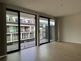 <p><span>Dit </span><span>quasi-nieuwbouwappartement</span><span> uit 2021 bevindt zich op de tweede verdieping in het centrum van </span><span>Kapellen</span><span>, met alle dagelijkse voorzieningen binnen handbereik. </span><span>Openbaar vervoer bevindt zich voor de deur</span><span> en ook het gemeentepark ligt op wandelafstand. Dankzij de centrale ligging zijn winkels, horeca en scholen vlot bereikbaar.</span></p><p><span>Via de lift of trap bereik je het appartement. De inkomhal leidt naar de ruime, lichtrijke </span><span>leefruimte</span><span> met grote raampartijen en toegang tot het </span><span>terras over de volledige breedte</span><span> van het appartement. De open keuken is volledig uitgerust met toestellen en sluit aan op een praktische berging met aansluitingen voor wasmachine en droogkast.</span></p><p><span>Verder beschikt het appartement over </span><span>2 ruime slaapkamers</span><span>, een badkamer met inloopdouche en dubbele lavabo en een apart toilet.</span></p><p><span>Troeven:</span></p><ul><li><span>EPC A = energiezuinig, zonnepanelen</span><span> </span></li><li><span>Groot terras</span><span> </span></li><li><span>Autostaanplaats en kelderberging inbegrepen</span><span> </span></li><li><span>Lift </span></li><li><span>Gemeenschappelijke fietsenstalling </span></li></ul><p><span>Huurprijs:</span><span> 1.200/maand / </span><span>Gemeenschappelijke kosten:</span><span> 90/maand<br />Nutsvoorzieningen af te sluiten op eigen naam.<br /></span><span>Beschikbaar vanaf 1 december 2026.</span></p><p><span>Interesse in dit moderne appartement? Vul de bezoekaanvraag onderaan de advertentie op </span><span><span>www.sinjoor.be</span></span><span> in en beantwoord alle vragen. De dossierverantwoordelijke neemt daarna contact met je op.</span></p><p><span> </span></p><p><span> </span></p>