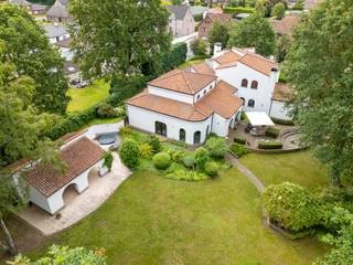 Deze unieke villa in Houthalen-Helchteren onderscheidt zich door haar karaktervolle architectuur met speelse rondingen en een tijdloze vormgeving. Gebouwd in 1998 en gelegen op een uitzonderlijk perceel van 4.470 m², biedt deze ruime woning met een bewoonbare oppervlakte van 394 m² alle troeven voor comfortabel wonen: royale leefruimtes, veelzijdige indelingsmogelijkheden en een uitstekende energie-efficiëntie.<br />De woning ademt karakter door haar organische vormen: van de eetkamer tot de zithoek met sierlijke halfronde ramen die het buitenlicht binnenhalen. De vele raampartijen zorgen doorheen de hele woning voor een warme, lichte sfeer die u onmiddellijk thuis doet voelen.<br /><br />Indeling: Master bedroom met aangrenzende badkamer, ruime leefruimtes en een sfeervolle keuken, grote berging en dubbele garage. Polyvalente ruimte (+-100m2): een grote extra ruimte die u naar eigen wens inricht als feestzaal, fitnessruimte, hobbyatelier of professionele werkzone, vrij beroep/kantoor en met rechtstreekse toegang door de grote kelder.<br /><br />Op de verdieping bevinden zich drie slaapkamers en een tweede badkamer — tevens inzetbaar als volledig autonome studio met eigen leefruimte, keuken, badkamer en twee slaapkamers. <br /><br />De volledige woning is onderkelderd (met plafondhoogte van 2.40m), goed voor +-263m2.<br /><br />Op een perceel van 4.470 m² geniet u van een indrukwekkende tuin die rust, ruimte en privacy biedt. Of u nu wilt ontspannen, tuinieren of buiten ontvangen — deze buitenruimte biedt het allemaal. De prachtige volwassen tuin biedt verschillende zon-en schaduwplekjes.<br /><br />Buitengewone kenmerken: <br />- Ruime woning van 394 m² <br />- Perceel van 4.470 m²<br />- Unieke architectuur met speelse rondingen en karaktervolle details<br />- 4 slaapkamers en 2 badkamers<br />- Verdieping bruikbaar als autonome studio<br />- Polyvalente extra ruimte (feestzaal, sport, atelier…)<br />- Dubbele garage en volledige kelder<br />- Veel natuurlijk licht dankzij grote raampartijen<br />- Mogelijkheid tot vrij beroep/kantoor aan huis<br />- Ruime tuin met veel privacy