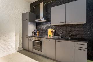 Als atelier vergunde triplex met koer<br /><br />Locatie<br />Dit bijzondere pand combineert het beste van twee werelden: de levendigheid van de stad binnen handbereik en tegelijk een aangename rust dankzij de achterin gelegen positie. Op wandelafstand bevinden zich Park Spoor Noord, winkels, horecazaken en openbaar vervoer. Ook belangrijke invalswegen zijn vlot bereikbaar, wat zorgt voor een uitstekende verbinding van en naar de stad. Dankzij de ligging als achterbouw geniet je hier van een rustige woonomgeving zonder hinder van het drukke stadsverkeer. <br /><br />Beschrijving<br />Achter de gevel schuilt een verrassend en karaktervol triplex met een unieke indeling, verspreid over drie niveaus. Via het gelijkvloers kom je terecht in de ruime en lichtrijke leefruimte met open keuken. Aansluitend bevindt zich een gezellige koer. Op de eerste verdieping bevindt zich een volwaardige slaapkamer en een badkamer uitgerust met douche, lavabo en toilet. Ook de aansluiting voor een wasmachine is hier voorzien. De bovenste verdieping biedt een veelzijdige extra ruimte die naar wens kan worden ingericht als bureau, atelier en/of hobbyruimte. Dit pand is vergund als 'atelier'. Mogelijke maandelijkse verhuurwaarde: 1.250 euro excl. kosten.<br /><br />Verplichte vermeldingen<br />EPC: 168 kWh/m²<br />P-score: D<br />G-score: D<br />Stedenbouwkundige inlichtingen: Vg, Wg, Vkr, Gmo, Gvv