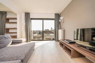 <p>Pal op 't Zuid gelegen, op wandelafstand van de bekende restaurants, cafés en koffiebars, is dit ruime appartement gelegen op de hoogste verdieping van residentie Hippodroom.<br /><br />Vanuit de inkomhal bereikt u de ruime leefkamer op bamboeparket waar er een zee van licht binnenstroomt door de vele raampartijen. Hier hebt u vanaf de middag tot de avond zon. De half open keuken met natuurstenen aanrecht is uitgerust met een elektrische kookplaat, een oven, een vaatwasmachine en een grote koelkast met diepvriezer. <br /><br />Aan de rustige achterzijde van het gebouw bevinden zich de twee slaapkamers met ingemaakte garderobe. In de vernieuwde badkamer met bad en douchescherm kan u relaxen in het bad of opkicken in de douche. Verder biedt een handig badkamermeubel veel opbergruimte. Het toilet is gescheiden. Tenslotte is er nog een bergruimte aanwezig in het appartement met een wasmachine. Het appartement beschikt ook over een ruime kelderberging.<br /><br />Een ondergrondse autostaanplaats nr 35 op -3 dient verplicht gehuurd te worden aan 125 €/maand.<br /><br />Pintjes gaan drinken in den Hopper, een koffiebreak houden in de Revista of heerlijk Italiaans eten in de Puro 26... Het kan hier echt allemaal. Het Zuid is de place to be voor wie rustig wil wonen en toch op 10 minuten wandelen in het centrum wil zijn. De goede verbinding naar de belangrijke invalswegen is een pluspunt.</p>