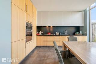 In deze perfect onderhouden woning waar karaktervolle en hedendaagse elementen worden samengebracht, geniet u van alle comfort. De woning biedt u een inkomhal, een charmante leefruimte met gaskachel, een moderne en strakke vernieuwde achterbouw met op maat gemaakte kasten en een totaal ingerichte keuken. De grote en hoge raampartijen zorgen voor veel natuurlijke lichtinval. Bovendien hebben we op het gelijkvloers een badkamer met inloopdouche, toilet en lavabo en een praktische berging/wasplaats. Op de eerste verdieping zijn er 2 grote slaapkamers. Het gezellige stadsterras is een extra troef in het centrum van de stad. De ramen zijn voorzien van dubbele beglazing en rolluiken aan de voorkant. Centrale verwarming op aardgas. Gunstige EPC score (label B). In de nabijheid van winkels, scholen, openbaar vervoer en op wandelafstand van de Grote Markt. Aarzel niet en maak vandaag nog uw afspraak.