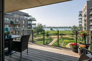 <p>Er zijn appartementen. En dan zijn er adressen die je dagelijks leven veranderen.<br /><br />Frontaal zicht op het Galgenweel. Niet vanuit een hoek, niet gedeeltelijk, maar recht voor je neus, elke ochtend opnieuw. Het water, de rust, het licht dat danst op het oppervlak. En jij, op een terras van 36 m², met nergens anders te hoeven zijn.<br /><br />36 m² terras. Dat is geen terras, dat is een buitenkamer. Met dat uitzicht als decor wordt elke avond vanzelf een evenement.<br /><br />Binnen ademt het appartement dezelfde kwaliteit. Twee volwaardige slaapkamers (waarvan 1 met opvouwbed) en een strakke badkamer met inloopdouche die van elke ochtend een moment voor jezelf maakt.<br /><br />Ook praktisch scoort dit appartement moeiteloos punten: een ondergrondse parkeerplaats met laadpaal en een eigen kelderberging zijn inbegrepen in de prijs!<br /><br />Dit is geen appartement om in te wonen. Dit is er één om van te genieten. Elke dag, in elk seizoen, met een uitzicht dat nooit verveelt.<br /><br />Troeven: – Frontaal zicht op het Galgenweel – Terras van 36 m² – 2 slaapkamers – Badkamer met inloopdouche – Ondergrondse parking met laadpaal – Kelderberging</p>