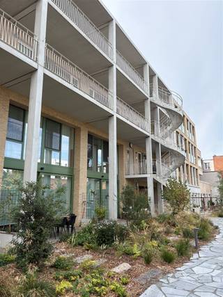 <p>Cet appartement neuf, lumineux et économe en énergie, est situé au cœur du Vieux-Berchem, dans le projet « De Wastuin ». Cafés, supermarchés, transports en commun et la gare de Berchem sont tous accessibles à pied. Bien que tout soit à proximité, c'est un quartier merveilleusement calme où il fait bon vivre.</p><p>L'appartement est flambant neuf et n'est mis en location que pour la deuxième fois.</p><p>On accède à « De Wastuin » par le jardin commun. L'appartement se trouve au deuxième étage et dispose d'une petite terrasse (ouverte) agréable juste devant la porte d'entrée.</p><p>On entre dans l’appartement par un petit hall ouvert, qui mène directement au salon et à la cuisine ouverte. La cuisine est équipée de tout le confort moderne : un lave-vaisselle, un réfrigérateur avec compartiment congélateur, un four combiné et une plaque à induction.</p><p>Un petit couloir donne accès à la salle de bains, équipée d’une baignoire-douche et d’un lavabo, aux toilettes séparées pour les invités et aux deux chambres. Enfin, l’appartement dispose d’un local technique séparé, qui sert également de buanderie.</p><p>Particularités : appartement économe en énergie avec compteurs individuels ; local à vélos et terrasse (ouverte) donnant sur le magnifique jardin intérieur verdoyant (commun).</p><p>Loyer : 1 185 € + 100 € de charges = 1 285 € par mois.</p>