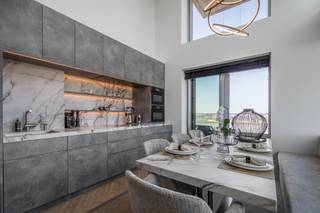 <p><strong>Ontdek dit exclusieve eigendom, perfect afgewerkt met luxueuze details en moderne technologie.</strong></p>
<p>Dit uitzonderlijke appartement is hoogwaardige afgewerkt. Overal is er maatwerk voorzien, waaronder luxueuze ingebouwde kasten, zelfs onder de bedden en zitbanken. De keuken is volledig op maat gemaakt, waarbij het design van de eettafel en salontafel naadloos aansluit op het keukenblad. De dubbele hoge plafonds in de keuken en eetkamer zorgen voor een ruimtelijk gevoel en geven een extra vleugje grandeur.</p>
<p>Een Sonos-geluidssysteem biedt een hoogwaardige audiobeleving in zowel het salon als de keuken. Dankzij het uitgebreide domoticasysteem kunt u met één druk op de knop alle verlichting en elektrische apparaten in- en uitschakelen. Automatische jaloezieën en gordijnen bieden comfort en privacy en kunnen afzonderlijk of centraal vanuit de keuken bediend worden. Voor wijnliefhebbers is er een speciale wijnkast in de wasruimte, die ook een extra diepvriezer, wasmachine en droogkast herbergt.</p>
<p>De keuken is uitgerust met top-of-the-line Miele-apparatuur en als extra is er een uittrekbare werktafel. Bovendien zijn de kasten volledig gevuld met servies, potten, pannen en diverse andere keukenbenodigdheden, zodat het je aan niets ontbreekt.</p>
<p>De design ensuite badkamers zijn beide afgewerkt met doorlopend natuursteen voor een verfijnde uitstraling en zijn voorzien van een dubbele wastafel en inloopdouche. In het salon bevindt zich een slaapsofa op een zijden tapijt beide van topkwaliteit.</p>
<p>De prijs omvat het volledige plaatje zijnde het appartement incl. inboedel (meubels en inhoud kasten), de kelderberging en de 2 autostaanplaatsen. De verkoop valt onder het btw-regime.</p>
Voor meer info of een afspraak voor een persoonlijke rondleiding contacteer je Ellen via mail Ellen@reds.be of 0474 84 54 29