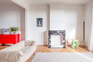 Het gevoel van een herenhuis op de vijfde verdieping.<br /><br />Kijkdagen 2 en 3 oktober, op afspraak: https://calendly.com/grotesteenweg21/new-meeting of WhatsApp 0473 42 47 74.<br /><br />Hoge plafonds, authentieke details en royale woonvolumes geven dit Art Déco-appartement karakter. Veel daglicht, verre zichten, twee ruime slaapkamers, lift, balkon en overdekt terras.<br />124 m² volgens EPC; 136 m² inclusief buitenmuren.<br />Gerenoveerd in 2022 · EPC C · elektriciteit conform · asbestveilig · geen renovatieplicht.<br /><br />Wonen met karakter<br />De eigenaar, zelf architect, ontwierp keuken en badkamer. De moulures werden gerestaureerd, het terrazzo hersteld en doorgetrokken tot op het terras. Het originele parket bleef behouden; de radiatoren werden gezandstraald en gelakt. Plafonds: 3,06 m.<br /><br />Indeling<br />Inkomhal met apart toilet en berging. Woonkamer, eetkamer en keuken lopen in elkaar over. Een gang leidt naar de badkamer met ligbad en douche en twee ruime slaapkamers achteraan. Balkon: 2 m² (NO); overdekt terras: 5 m² (ZW).<br /><br />Het gebouw<br />Berchem Palace, boven Campo & Campo, werd in 1928 ontworpen door François Dens en is vastgesteld bouwkundig erfgoed. Rustig gebouw met 12 appartementen en fijne buren. Achtergevel recent geïsoleerd en gerenoveerd; terrassen en balustrades vernieuwd. Lift, droge privatieve kelder van 11 m² en eigen warmwaterboiler op gas.<br />Kosten: € 85/maand + € 165/maand voor de verwarming van het appartement (gasinstallatie met vernieuwde ketel).<br /><br />De buurt<br />Tramhalte De Merode voor de deur; station Berchem op een kwartier wandelen. Albert Heijn, Aldi, De Barn en koffiebars Funk, Betty en Notti op wandelafstand. Albertpark, Harmoniepark en de winkels bij Brouwerij De Koninck vlakbij. Klein Berchem, op de De Koninck-site, is in aanbouw met nieuwe handelszaken en buurtvoorzieningen.<br /><br />Biedingen<br />Per e-mail tot 7 oktober om 20u. Alle biedingen worden daarna samen bekeken.