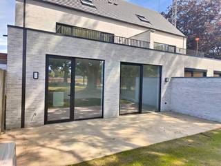 Deze gelijkvloerse woning biedt 2 slaapkamers, een hoogwaardige afwerking, duurzame technieken (vloerverwarming, lucht-waterwarmtepomp en zonnepanelen) een gemeenschappelijke fietsenberging en een privatieve autostaanplaats. Het zuidgerichte terras met ruime tuin laat je optimaal genieten van ruimte en het prachtige groene achterland. Stalen tussendeur tussen inkom en leefruimte nog te voorzien en inbegrepen in de prijs. Voordelig voor zowel eigen bewoning als voor investeerders wegens minieme gemeenschappelijke kosten + aankoop voor eigen bewoning mogelijk onder 6% btw!