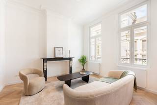 Ben je op zoek naar een trendy, instapklaar appartement op een toplocatie in Antwerpen? Dit recent gerenoveerde appartement ligt op de eerste verdieping van een gezellig, kleinschalig gebouw in de Nottebohmstraat. Gelegen om de hoek van de bruisende Dageraadplaats, woon je hier te midden van gezellige terrasjes, restaurants en de unieke sfeer van Zurenborg, terwijl je binnen geniet van rust en licht.<br /><br />Bij het binnenkomen valt meteen de indrukwekkende combinatie van moderne luxe en historische grandeur op. Dankzij de hoge plafonds, prachtige authentieke moulures en de grote raampartijen aan de straatzijde baadt de leefruimte in het natuurlijke daglicht. Het appartement ademt karakter dankzij twee prachtige authentieke marmeren schouwen. Vooraan bevindt zich de sfeervolle woonkamer en een eetplaats die naadloos aansluit op de gloednieuwe, volledig uitgeruste open keuken. Deze strakke keuken is hoogwaardig afgewerkt en voorzien van alle toestellen. Direct achter de leefruimte tref je de eerste volwaardige slaapkamer aan.<br /><br />Het appartement is verrassend ruim en slim ingedeeld. Via een charmant tussentrapje bereik je het achterste gedeelte van het appartement. Hier bevindt zich een handige bureauruimte, perfect voor wie regelmatig van thuis uit werkt. Verder herbergt dit gedeelte een apart toilet, een grote berging met alle aansluitingen voor een wasmachine en droogkast, en de tweede grote slaapkamer. De badkamer is uitgerust met een comfortabele inloopdouche, modern kraanwerk en een dubbel lavabomeubel. Het volledige appartement is bovendien voorzien van een schitterende, gloednieuwe visgraatparket die het geheel een warme uitstraling geeft. Als extra troef beschikt het appartement over een handige kelderberging voor extra opslagruimte.<br /><br />Zie jij jezelf al wonen op deze unieke droomlocatie in Antwerpen?<br />Maak snel een afspraak voor een bezichtiging via info@goose.be of bel naar 03 369 36 38.
