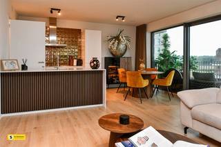 <p><span>TE KOOP : Dit prachtige nieuwbouwappartement is gelegen in Turnhout. Met zuidgericht terras en vrij zicht op het water, een topper qua uitzicht. </span></p><p><span>We betreden het appartement via de inkomhal. Hier vinden we de toegang tot de 2 ruime slaapkamers, beide voorzien van elektrische screens. Verder bevindt zich hier een badkamer met inloopdouche en dubbele lavabo. Naast de badkamer is er een apart toilet voorzien. Als we de gang uitlopen, komen we terecht in de ruime leefruimte met open keuken en prachtig uitzicht. Naast de keuken is er nog een berging/technische ruimte voorzien.   De nieuwe meubels en de stijlvolle aankleding van de muren zorgen ervoor dat dit zeer trendy appartement een streling voor het oog is. De meubels kunnen mee overgekocht worden, mits akkoord met de eigenaar.  Appartement is voorzien van zonnepanelen, ventilatiesysteem, domotica, parlofoon/videofoon en een lift.</span></p><p><span>Vaste kosten 125 euro/maand aan Syndicus, ongeveer 40 euro/maand aan Fluvius (verwarming)   </span><span>Opgelet: ondergrondse parkeerplaats verplicht bij aan te kopen voor 20.000 euro</span></p><p><span>Dit appartement kan verkocht worden onder BTW (21%) nieuwbouw</span></p><p><span>335.000 + 21% BTW </span></p>