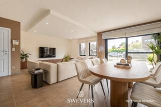 Voor meer info en foto’s, surf naar www.swevers.be – Dit instapklare gelijkvloerse appartement in het centrum van Zolder combineert een ruime indeling met aangenaam wooncomfort. Met een bewoonbare oppervlakte van 120 m², drie slaapkamers en een privatieve tuin rondom is dit een ideale woning voor wie comfortabel en gelijkvloers wil wonen. Het appartement maakt deel uit van een verzorgd gebouw uit 2007 en beschikt bovendien over een ondergrondse autostaanplaats en een kelderberging. Via de inkomhal bereikt u de ruime leefruimte van bijna 52 m², waar woonkamer en eetkamer naadloos in elkaar overvloeien. Dankzij de royale oppervlakte geniet u hier van alle vrijheid om een gezellige zithoek en een volwaardige eethoek in te richten. Aansluitend bevindt zich de praktische keuken met voldoende werk- en opbergruimte. De nachthal geeft toegang tot drie slaapkamers van respectievelijk 13,26 m², 9,51 m² en 9,07 m². Deze ruimtes zijn perfect inzetbaar als slaapkamer, bureau, hobbykamer of logeerkamer. De badkamer is uitgerust met zowel een bad als een douche. Daarnaast is er een aparte toiletruimte en een handige berging. Buiten geniet u van een tuin rondom het appartement, met een terras aan de voorzijde en een overdekt terras van 9,61 m² aan de achterzijde. De zuidwestgerichte achtertuin biedt volop zon in de namiddag en avond en vormt een aangename plek om tot rust te komen. Extra troeven zijn de zonnepanelen, rolluiken, parlofoon, lift en de vlotte verbinding tussen de ondergrondse parking en het appartement. Scholen, winkels, restaurants, openbaar vervoer en ontspanningsmogelijkheden bevinden zich op wandel- of korte rijafstand. Ook de snelwegen zijn snel bereikbaar. Voor meer informatie, bel 011 255 155. Bron bewoonbare oppervlakte: EPC – verslag.