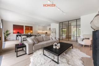 Dit exclusieve gelijkvloers appartement bevindt zich in een prachtig en zeer goed onderhouden gebouw op een uiterst gegeerde locatie, op een steenworp van de Vismarkt en in het bruisende hart van Leuven. Met een bewoonbare oppervlakte van 130 m² werd dit appartement van kop tot teen gerenoveerd, met oog voor detail, comfort en kwalitatieve materialen. U wordt verwelkomd in een inkomhal, stijlvol afgewerkt met een glazen stalen deur die de inkom- en nachthal elegant afscheidt van de leefruimte. De uitzonderlijk ruime leefruimte baadt in het licht dankzij de volledig beglaasde achtergevel en biedt een prachtig zicht op de privatieve tuin, een absolute zeldzaamheid in het centrum van Leuven. Vanuit de tuin geniet u bovendien van een uniek zicht op de Sint-Geertruikerk, het Klein Begijnhof en een charmante omgeving. De open keuken vormt de parel en het kloppend hart van het appartement, met een ruim keukeneiland, smaakvolle materialen, alle nodige toestellen en een aansluitende praktische berging. Via de nachthal bereikt u een apart gastentoilet, twee slaapkamers en een ruime badkamer met dubbele wastafel, grote inloopdouche en tweede toilet. Verder beschikt het appartement over een zeer ruime kelderberging, alsook verplichte aankoop van een ondergrondse garagebox (€50.000). Ook de stijlvolle meubels kunnen optioneel worden overgenomen. Een unieke woonkans waar luxe, rust en centrumligging samenkomen. Interesse? Contacteer ons via info@homies.be / 016 22 82 22.