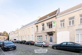 Gelegen in de Vleeschouwersstraat, op amper 100 meter van de Grote Markt van Veurne, bevindt zich deze volledig gerenoveerde en beschermde herenwoning. Dankzij de centrale ligging bevinden scholen, winkels, horeca, openbaar vervoer en alle dagelijkse voorzieningen zich op wandelafstand.<br /><br />De woning is volledig instapklaar en beschikt over 3 slaapkamers en 2 badkamers. Dankzij de ruime indeling is ze geschikt als gezinswoning, maar biedt ze ook mogelijkheden voor wie een combinatie zoekt met een bureau of een vrij beroep.<br /><br />Op het gelijkvloers komt u binnen via de royale inkomhal, met afzonderlijk gastentoilet. Vanuit de inkomhal heeft u toegang tot de slaapkamer en de bureauruimte. De huidige bureauruimte is voorzien van een gashaard en kan uiteraard ook als derde slaapkamer worden ingericht. Verder is er toegang tot de gezellige binnenkoer, met aansluitend een praktische berging met voorzieningen voor wasmachine en droogkast.<br /><br />De slaapkamer op het gelijkvloers beschikt over een eigen badkamer met douche, wat deze verdieping extra praktisch maakt.<br /><br />Via de trap bereikt u de eerste verdieping, waar de ruime en bijzonder lichtrijke leefruimte zich bevindt. De hoge plafonds en grote raampartijen zorgen hier voor een aangenaam ruimtelijk gevoel. De leefruimte is voorzien van een hoogwaardige parketvloer en sluit aan op de volledig geïnstalleerde open keuken met ontbijtmeubel.<br /><br />Op deze verdieping bevindt zich eveneens de tweede badkamer, uitgerust met een douche, bad, enkele wastafel en toilet.<br /><br />De tweede verdieping omvat twee ruime slaapkamers, beide voorzien van ingemaakte kasten. Via de nachthal is er toegang tot de zolder, die extra bergruimte biedt.<br /><br />Achteraan de woning bevindt zich een gezellig terras, een aangename plek om in alle rust van de buitenlucht te genieten.<br /><br />Ook op energetisch vlak beschikt de woning over een goede basis. Er is centrale verwarming op aardgas, het dak werd geïsoleerd en de woning beschikt over dubbele beglazing in houten schrijnwerk.<br /><br />Een karaktervolle woning met veel ruimte, licht en mogelijkheden, gelegen op een bijzonder centrale locatie in het hart van Veurne.<br /><br />Voor meer informatie of een bezoek kunt u contact opnemen met Inti via inti@immofrancois.be of 0499 74 89 74.<br /><br />