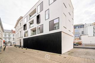 This modern new-build apartment, measuring a spacious 130 m², is located in a prime location in the historic center of Ghent, between Onderbergen and Posteernestraat. Here, you will live amidst the bustling city, with Korenlei, charming restaurants, boutiques, and cultural hotspots within walking distance – yet in a quiet, charming street.<br /><br />The apartment welcomes you with a stylish entrance hall equipped with a cloakroom and guest toilet.<br />The bright open living space offers an ideal layout with a dining area, cozy reading corner, and a fully equipped modern kitchen with an adjoining pantry. Large windows along the entire wall provide an abundance of natural light and a pleasant feeling of space. From the living area, you have access to a spacious indoor terrace – an oasis of peace in the middle of the city.<br /><br />The apartment also features two bedrooms, a shower room, and a luxurious bathroom equipped with a bath, shower, and double sink.<br />In addition to the high-quality finish, the property is technically equipped with underfloor heating and ventilation.<br /><br />An underground parking space is available for €50,000 and must be purchased together with the apartment.<br /><br />This property combines contemporary living comfort with a unique location in one of the most coveted neighborhoods in Ghent – ideal for those who appreciate refinement, tranquility, and urban elegance.<br />Sale under registration fees.