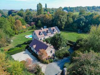 <p>In a sought-after rural setting near the golf course and St. John's International School, this elegant family home, built in 2000 and renovated in 2022, offers ± 564 m² of living space (PEB) on over 56 ares with a heated pool. A second building, ideal for a practice, concierge or guest use, completes the property.</p>
<p>The villa opens to a spacious hall with cloakroom. The bright living room with fireplace connects to a large, fully equipped kitchen with island and dining area, extended by a study/library corner. The first floor includes two children’s bedrooms with dressing rooms, a shower room, and a master suite of 50 m² with bathroom and dressing. The top floor features two large bedrooms, each with an en-suite. The basement houses a wine cellar, utility room, and storage space with access to a ventilated crawl space. The annex initially included four garages; two were converted into a fitness room, and a comfortable apartment occupies the upper level.</p>
<p>Additional features: two terraces, double gate, alarm system, videophone, rainwater tank, air conditioning in bedrooms, heat pumps, oil heating, wooden double-glazed windows, and 30 solar panels.</p>
<p>Ohain in Lasne is renowned for its prestigious villas, charming landscapes, and listed village square.</p>
<p>For further information and visits, please contact our office in Walloon Brabant on +32 (2) 898.09.40.</p>