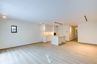 Dit gelijkvloers nieuwbouwappartement van 99 m² (bruto) maakt deel uit van een kleinschalige residentie met slechts 5 appartementen en is gelegen in het centrum van Zandhoven. Het appartement beschikt over 2 slaapkamers, een zuidwestgericht terras van 13,2 m², een privatief tuintje, een ondergrondse autostaanplaats en een private berging.<br /><br />Indeling<br />Via de inkomhal met vestiairekast en apart gastentoilet komt u in de ruime leefruimte van 43,6 m². Dankzij de grote raampartijen geniet de leefruimte van veel natuurlijk licht en heeft u rechtstreeks toegang tot het terras en de tuin.<br /><br />De open keuken is volledig ingericht en voorzien van:<br />- keramisch werkblad<br />- Quooker-kraan<br />- inductiekookplaat<br />- combi-oven<br />- koelkast met aparte diepvriezer<br />- ruim kookeiland<br />- veel opbergkasten<br /><br />De badkamer is uitgerust met een inloopdouche, een dubbel lavabomeubel, een badkamerkast en een handdoekdroger.<br /><br />Verder beschikt het appartement over twee slaapkamers en een afzonderlijke berging met aansluitingen voor wasmachine en droogkast, de warmtepomp en het ventilatiesysteem.<br /><br />Afwerking en technieken<br />Het volledige appartement is afgewerkt met een keramische parketvloer en wordt volledig geschilderd opgeleverd.<br /><br />Daarnaast zijn inbegrepen:<br />- alle verlichtingsarmaturen<br />- Louverdrape lamelgordijnen in de leefruimte<br />- verduisterende raamdecoratie in de slaapkamers<br />- vliegenramen op maat<br /><br />Voor verwarming en sanitair warm water wordt gebruikgemaakt van een Daikin warmtepomp in combinatie met vloerverwarming. Met dit type verwarmingssysteem kan de vloer ook gekoeld worden, wat het enorm aangenaam leven maakt bij warme zomerdagen. Het appartement beschikt bovendien over 4 privatieve zonnepanelen, Niko Home Control-domotica en behaalt een E-peil van E13, wat resulteert in een zeer energiezuinige woning.<br /><br />Extra<br />- Ondergrondse autostaanplaats<br />- Private berging <br />- Zuidwestgericht terras van 13,2 m²<br />- Privatief tuintje van ca. 17 m²<br />- Bushalte, winkels, horeca en andere voorzieningen op wandelafstand.<br /><br />*3m HWB<br />*Plaatsbeschrijving<br />*Beschikbaar vanaf 15/08/2026<br />* EPB in opmaak - nieuwbouw