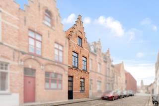 Deze charmante woning biedt een uitstekende ligging in het hart van Brugge, op wandelafstand van het pittoreske Minnewater. De woning heeft een leuke gevel en een karaktervolle uitstraling.

Bij binnenkomst kom je in een ruime inkomhal, die toegang biedt tot de gezellige leefruimte. Aansluitend bevindt zich de keuken, met zicht op een stadstuintje en terras, ideaal om te ontspannen of te genieten van de zon. Op het gelijkvloers is momenteel ook een badkamer voorzien.

Op de eerste verdieping bevinden zich 2 slaapkamers, en via een vaste trap bereik je het tweede verdiep, waar nog eens 2 extra slaapkamers zijn.

De woning is te renoveren, waardoor je de mogelijkheid hebt om ze volledig naar eigen smaak in te richten. Dankzij de topligging en het potentieel van de woning biedt dit een unieke kans voor wie houdt van het bruisende stadsleven én de charme van Brugge wil combineren met persoonlijke touch en renovatiemogelijkheden.

Ben jij op zoek naar een woning in het centrum van Brugge? Contacteer makelaar Stéphanie 0472 77 86 60 of stephanie@keyimmo.be voor een bezoek.