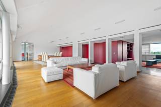 In het centrum van Brasschaat bevindt zich dit bijzonder ruime en lichtrijke penthouse, ontworpen door architect Jef Van Oevelen. Het appartement combineert een hoogwaardige afwerking met royale leefruimtes, twee terrassen en een uitzonderlijk centrale ligging. Winkels, supermarkten, restaurants, de bibliotheek en het Park van Brasschaat bevinden zich allemaal op wandelafstand.<br /><br />Via de lift bereiken we rechtstreeks de ruime inkomhal van het appartement, afgewerkt met een tegelvloer. Van hieruit betreden we de indrukwekkende leefruimte van ca. 95 m², voorzien van massief eiken parket. De grote raampartijen over de volledige breedte zorgen voor een bijzonder aangename lichtinval en geven rechtstreeks toegang tot het ruime zuidwestgerichte dakterras van ca. 38 m², met panoramisch zicht over Brasschaat.<br /><br />Aansluitend aan de leefruimte bevindt zich een tweede salon/tv-ruimte van ca. 31 m², voorzien van een ingemaakte tv- en barkast en aansluiting voor speakers. <br /><br />De volledig geïnstalleerde keuken beschikt over een kookeiland met eethoek en is uitgerust met onder meer een inductiekookplaat, vaatwasser, oven, stoomoven en ingebouwde friteuse van Miele. Dankzij de vele ingemaakte kasten is er bovendien voldoende bergruimte voorzien. Vanuit de keuken is er toegang tot een tweede terras van ca. 6 m².<br />Aansluitend bevindt zich een praktische bijkeuken/wasplaats met aansluitingen voor wasmachine en droogkast.<br /><br />Verder beschikt het appartement over een gastentoilet met lavabo en een afzonderlijke bureauruimte van ca. 20 m², volledig op maat uitgevoerd in notenhout.<br />Deze ruimte kan indien gewenst worden ingericht als volwaardige slaapkamer.<br /><br />Het nachtgedeelte omvat een royale dressing die toegang geeft tot de master bedroom. Aansluitend bevindt zich de ensuite badkamer, uitgerust met een notenhouten lavabomeubel met twee opzetwastafels, een ruime inloopdouche en toilet.<br /><br />Via een vaste trap is bovendien nog een zolderverdieping bereikbaar, die bijkomende bergruimte biedt.<br /><br />Het appartement werd doorheen de jaren bijzonder goed onderhouden en is afgewerkt met kwalitatieve materialen en tal van ingemaakte kasten. Het beschikt over vloerverwarming met afzonderlijke circuits, gasverwarming via een Viessmann-installatie en airconditioning doorheen het appartement. <br /><br />Bij het appartement zijn tevens een dubbele garagebox met automatische poort en een private kelderberging inbegrepen.<br /><br />Troeven:<br />+ Centrale ligging in Brasschaat<br />+ Royale en lichtrijke leefruimte van ca. 95 m²<br />+ Zuidwestgericht dakterras van ca. 45 m²<br />+ Tweede terras van ca. 6 m²<br />+ Vloerverwarming en airconditioning<br />+ Dubbele garagebox met automatische poort<br />+ Private kelderberging<br />+ Gunstig EPC – B<br /><br />Interesse in dit appartement?<br />Contacteer ons via 03 337 50 70 of info@vbvastgoed.be voor meer info of een bezoek ter plaatse.