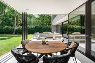 <p><span>Luxe villa in moderne stijl met vele mogelijkheden gelegen op een zeer rustige locatie met veel privacy omringd door natuur.</span></p><p><span> </span></p><p><span>Indeling</span></p><p><span>U betreedt de villa middels de centrale inkomhal met gastentoilet en doorgang naar de leeftuimte, trap naar de verdieping en kelder. Wanneer u de leefruimte binnengaat, ervaart u ineens een prachtig zicht over de tuin via de grote glazen schuiframen naar tuin en terras. De leefruimte omvat een zitkamer, een aparte televisiekamer of bureel aan de voorzijde van de villa, een centrale eetkamer met aansluitend de open leefkeuken met eiland. Vanuit de keuken een doorgang naar berging en aansluitend de inpandige garage. </span></p><p><span> </span></p><p><span>Verdieping</span></p><p><span>De nachthal geeft toegang tot de hoofdslaapkamer met aansluitende dressingkamer, een ruime badkamer en nog twee ruime slaapkamers, allen met zicht op de tuin en toegang tot een balkon over de breedte van de woning. Aan de voorzijde van de villa bevindt zicht nog een grote wasplaats met aansluitingen voor wasmachine en droger, welke ruimte ook kan worden aangewend als een vierde slaapkamer of een tweede badkamer. </span></p><p><span> </span></p><p><span>Kelder of souterrain</span></p><p><span>In de kelder werden meerdere functionele ruimtes gecreëerd met volwaardige hoogte en hier vinden wij momenteel een technische ruimte, een berging, polyvalente ruimte welke heden als trainingsruimte of vergaderzaal wordt gebruikt. Mogelijkheid tot het inrichten van een thuisbioscoop of fitness. </span></p><p><span> </span></p><p><span>Tuin en buitenruimtes </span></p><p><span>De parktuin geniet veel privacy en een optimale zonligging. Aan de achterzijde van de woning bevindt zich een overdekt terras welke bereikbaar is vanuit de keuken. Het perceel is omheind en voorzien van een automatische poort.</span></p><p><span> </span></p><p><span>Bijzonderheden</span></p><p><span>Deze design villa combineert hedendaagse luxe met moderne technieken voor optimaal comfort en laag energieverbruik. De grote kelder biedt mogelijkheden voor werken uit huis, fitness of andere hobby's. Het eigendom is zeer rustig gelegen in een bosrijke omgeving, in een doodlopende straat, en toch op slechts enkele minuten van de dorpskern van Kapellen verwijderd.</span></p><p><span> </span></p><p><span>Meer inlichtingen via ons kantoor.</span></p>