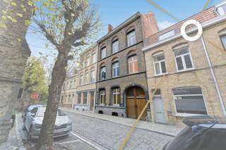 Aan de voet van de vestingen, in de schaduw van de Sint-Jacobskerk en pal in het hart van Ieper, bevindt zich deze karaktervolle herenwoning met uitzonderlijk grote tuin en bijgebouw. U betreedt het pand via de imposante toegangspoort, ooit doorgang voor koetsen, die vandaag kan uitgroeien tot een majestueuze inkomhal met directe toegang tot zowel de woning als de tuin. Op het gelijkvloers bevinden zich onder meer een voorkamer, traphal, woonkamer, aparte keuken, badkamer en slaapkamer. Daarboven wachten nog drie verdiepingen om volledig naar eigen smaak te worden ingericht. Met wat renovatiewerk en visie maakt u van dit pand één van de meest opvallende herenwoningen van Ieper – een unieke kans voor wie ruimte, authenticiteit en een topligging in het centrum zoekt.