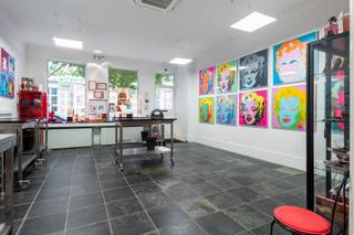 <p>Op sommige plekken in Antwerpen hoef je de locatie nauwelijks nog uit te leggen.<br />De Kloosterstraat kent iedereen. Antiek, design, kleine boetieks, koffie, restaurants en altijd wel iets te ontdekken. En net om de hoek, in de Korte Vlierstraat, staat dit karaktervolle handelshuis.<br />Een pand met 294 m² ruimte, een flinke dosis persoonlijkheid en vooral: mogelijkheden.</p>
<p>We beginnen beneden.<br />Vandaag bevindt zich hier een chocoladeatelier. En eerlijk? Dat klinkt op zich al behoorlijk goed.<br />Maar het handelsgelijkvloers hoeft uiteraard niet naar chocolade te blijven ruiken. Met zijn grote open ruimte en etalage aan de straatzijde kan je hier heel wat kanten uit. Een winkel, atelier, showroom, kantoor, praktijk, creatieve studio… Wie droomt van een eigen zaak met een sterke zichtbaarheid en een toplocatie, mag hier alvast beginnen dromen. En bovendien zijn hier 2 wc's voorzien.<br />Achteraan bevindt zich een keuken en dankzij de aparte meters kan het handelsgedeelte bovendien mooi functioneren naast het woongedeelte.</p>
<p>En dan gaan we eerst even naar de kelder.<br />Geen plek waar je tussen spinnenwebben en oude verfpotten naar de watermeter moet zoeken. Hier werden de authentieke bakstenen gewelven net uitgespeeld en kreeg de ruimte zowaar een eigen bar.<br />Een verborgen plek onder de stad, ideaal als extra ontspanningsruimte, wijnkelder of gewoon als die plek waar een avond soms iets langer duurt dan gepland.</p>
<p>Vanaf de eerste verdieping begint het privéleven.<br />En na de uitgesproken commerciële ruimte beneden verandert de sfeer hier helemaal. Een ruime leefkamer met houten vloer biedt plaats aan zowel salon als eetkamer. De open keuken is gloednieuw (2024), uitgerust met gootsteen, inductiekookplaat (4 pitten) en ingebouwde dampkap.</p>
<p>Aansluitend ligt een gezellige buitenruimte. Een groen hoekje midden in de stad om heerlijk te genieten van een tasje koffie, aperitief in de zon of gewoon vijf minuten eens helemaal niets te doen.</p>
<p>Op de 2de verdieping bevindt zich de grote slaapkamer met aparte dressing en daarnaast een ruime badkamer. En ook die past helemaal bij het karakter van het huis: een groot ligbad, aparte douche en een eigenzinnige zwart-witte vloer.</p>
<p>Helemaal boven wachten nog twee kamers.<br />Slaapkamers, hobbyruimtes,… kies maar.<br />En dan is er nog het uitzicht.<br />Want boven de daken krijg je Antwerpen er zomaar bij. Met onder andere de kathedraal aan de horizon. Niet slecht als achtergrond bij je eerste koffie van de dag.</p>
<p>De Kloosterstraat ligt letterlijk om de ene hoek, de Sint-Andriesplaats om de andere hoek. De vernieuwde Scheldekaaien en het Zuidpark zijn vlakbij en voor leuke winkels, koffie of een goed restaurant hoef je hier zelden ver te wandelen. Bovendien zijn er plannen om de straat als woonerf in te richten.</p>
<p>Dit is dan ook geen woning die zich makkelijk in één vakje laat stoppen.<br />Het is een handelspand, een woning, een werkplek en vooral een plek met karakter.</p>
<p>Troeven:<br />– toplocatie <br />– handelsgelijkvloers, huidige eigenaars zijn bereid dit te huren tegen marktconforme voorwaarden, valt zeker en vast te bespreken!<br />– aparte meters <br />– buitenruimte <br />– kelder met bar <br />– airco <br />– EPC C, inclusief 12 zonnepanelen<br />- Prachtig uitzicht</p>