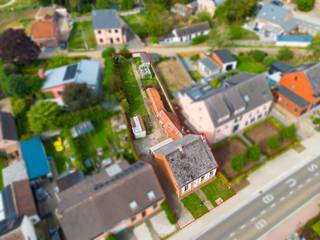 <h2><span>Altijd al gedroomd van een karaktervolle hoeve die u volledig naar eigen smaak kunt renoveren?</span></h2>
<p><span>Deze authentieke woning uit 1910, gelegen op een mooi perceel van maar liefst </span><strong><span>740 m²</span></strong><span>, barst van het potentieel. Rond 2008 onderging de woning reeds een kleine renovatie, maar vandaag biedt ze vooral een unieke kans voor wie op zoek is naar een pand met karakter én mogelijkheden.</span></p>
<p><span>De charmante gevel verraadt meteen de authentieke ziel van de woning. Binnen vormt de compacte, gezellige woonkamer samen met de eetkamer een knusse leefruimte. De aangrenzende keuken biedt voldoende plaats en kijkt uit op de tuin.</span></p>
<p><span>Via de trap bereikt u de eerste verdieping, waar zich een </span><strong><span>ruime (80m²) polyvalente zolderruimte</span></strong><span> bevindt. <br />Een interessante oppervlakte die, mits de nodige aanpassingen en vergunningen, tal van mogelijkheden biedt.</span></p>
<p><span>Wat u op het eerste gezicht misschien niet ziet, maar ongetwijfeld zult waarderen, is de </span><strong><span>achtertoegang via de achtergelegen straat</span></strong><span>. Dit creëert interessante mogelijkheden voor bijvoorbeeld een carport, extra parkeerplaats of een praktische toegang tot de tuin.</span></p>
<p><span>Het perceel is bovendien zuid-</span>westelijk georiënteerd<span>, waardoor u hier op zonnige namiddagen en avonden volop van het buitenleven kunt genieten.</span></p>
<p><span>Ook de ligging is bijzonder interessant. </span><strong><span>Scholen, winkels, restaurants en openbaar vervoer bevinden zich op minder dan 300 meter</span></strong><span>, terwijl de snelwegen op slechts circa 4 kilometer liggen. Zo combineert u een landelijke woonomgeving met een vlotte verbinding naar de omliggende dorpen en belangrijke invalswegen.</span></p>
<p><span>Kortom: een bijzondere opportuniteit voor wie op zoek is naar </span><strong><span>authenticiteit, ruimte en renovatiepotentieel</span></strong><span>. Met de juiste visie, wat liefde en een persoonlijke toets kan deze karaktervolle woning uitgroeien tot een prachtige thuis voor de toekomst.</span></p>
<p><strong><span>Extra troeven:</span></strong></p>
<ul>
<li><span>Elektrische installatie conform</span></li>
<li><span>Perceel van 740 m²</span></li>
<li><span>Achtertoegang via achtergelegen straat</span></li>
<li><span>KI van slechts € 294!</span></li>
</ul>