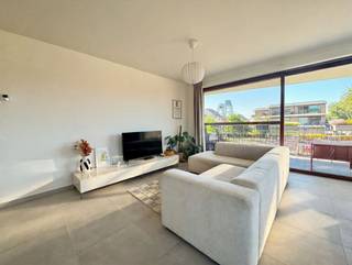 <p>In de hedendaagse en stijlvolle residentie Vredebrug bevindt zich dit aangename appartement op de eerste verdieping. Dankzij de moderne architectuur, de praktische indeling en de grote raampartijen geniet je hier van een comfortabele en lichtrijke woonomgeving.</p><p>Via de diepe inkomhal betreed je het appartement, waarna je terechtkomt in de ruime woonkamer. Dankzij de grote raampartijen valt er bijzonder veel natuurlijk licht binnen en ontstaat er een aangename, open sfeer. De woonkamer sluit mooi aan op de volledig uitgeruste open keuken, waardoor koken en gezellig samenzijn hier moeiteloos samengaan.</p><p>Het appartement beschikt over twee volwaardige slaapkamers, een moderne badkamer met ligbad, een apart toilet en een praktische berging die tevens dienst doet als wasplaats.</p><p>Een bijkomende troef is het aangename terras van maar liefst 17 vierkante meter, waar je heerlijk kan genieten van de buitenlucht. Daarnaast beschikt de woning over een ruime kelderberging, ideaal voor extra stockage.</p><p>Ook op vlak van mobiliteit is het appartement bijzonder praktisch. Er zijn drie overdekte fietsplaatsen voorzien en er kan een ondergrondse autostaanplaats mee worden aangekocht.</p><p>Dit appartement op de eerste verdieping combineert moderne architectuur, moderne technieken zoals vloerverwarming, veel lichtinval, comfort en een praktische indeling en vormt daarmee een ideale thuis voor wie hedendaags en aangenaam wil wonen in Residentie Vredebrug.</p>