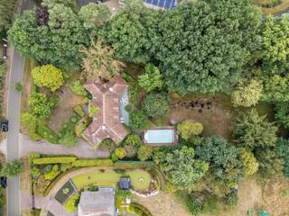 Ruime villa op een uitzonderlijk groot perceel van 4.561 m², residentieel gelegen in de gewilde villawijk ‘Grote Heide’ te Pelt. De woning biedt bijzonder veel ruimte, zowel binnen als buiten, en beschikt over een zeer complete indeling met onder meer vijf slaapkamers, drie badkamers, meerdere leefruimtes, een kantoor en een dubbele inpandige garage.<br /><br />De villa is doorheen de jaren goed zeer goed onderhouden, maar de afwerking en inrichting zijn enigszins gedateerd en bieden ruimte voor modernisering en opfrissing. Dit biedt nieuwe eigenaars de mogelijkheid om de woning naar eigen smaak en hedendaagse woonnormen te renoveren en opnieuw tot een bijzonder ruime en comfortabele gezinsvilla te transformeren.<br /><br />Gelijkvloers<br />Via de ruime inkomhal met gastentoilet heeft u toegang tot de verschillende leefvertrekken. De royale leefruimte is ingedeeld in een afzonderlijke zithoek, een eetkamer en een aparte bibliotheek/TV-kamer. Dankzij de grote raampartijen is er een aangename verbinding met de tuin en geniet de woning van een mooie natuurlijke lichtinval.<br />De ruime ingerichte keuken sluit rechtstreeks aan op de praktische wasplaats/berging.<br />Verder beschikt het gelijkvloers over een afzonderlijke kantoorruimte en een dubbele inpandige garage, geschikt voor het stallen van twee wagens.<br /><br />Eerste verdieping<br />De eerste verdieping omvat een ruime masterbedroom met dressing en een ingerichte ensuite badkamer, uitgerust met een douche, sauna, dubbele wastafel, ligbad en apart toilet.<br />Daarnaast zijn er nog vier bijkomende slaapkamers, allemaal voorzien van inbouwkasten. Eén van deze slaapkamers beschikt over een afzonderlijke douchekamer.<br /><br />De nachthal geeft verder toegang tot een extra badkamer, uitgerust met een douche, ligbad en dubbele wastafel, evenals een afzonderlijk toilet.<br /><br />De royale oppervlakte en praktische indeling maken deze verdieping bijzonder geschikt voor een groot gezin of voor wie nood heeft aan meerdere slaapkamers, hobby- of werkruimtes.<br /><br />Tuin<br />Een van de absolute troeven van deze eigendom is het uitzonderlijk grote perceel van 4.561 m². De ruime tuin biedt volop privacy en mogelijkheden en beschikt over een buitenzwembad en praktische tuinberging.<br />De combinatie van het royale perceel, de bestaande buitenvoorzieningen en de residentiële ligging maakt deze woning bijzonder interessant voor wie op zoek is naar ruimte en potentieel in een groene omgeving.<br /><br />Bijzonderheden<br />•Bouwjaar 1991<br />•Verwarming op stookolie<br />•Alarm aanwezig<br />•Beregeninginstallatie op grondwater<br />•Ideale opportuniteit om de villa naar eigen smaak en hedendaagse normen te renoveren<br />EPC: 270 kWh/m²