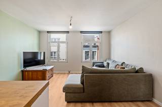 Dit centraal gelegen, instapklaar appartement bevindt zich in het centrum van Merksem. Vanzelfsprekend zijn alle noodzakelijke voorzieningen zoals winkels, scholen, openbaar vervoer en de oprit van de snelweg, vlot bereikbaar. Dankzij de centrale ligging biedt het appartement een prima verbinding met de stad Antwerpen. U komt het appartement op de eerste verdieping binnen via een aparte inkomhal, die meteen toegang geeft tot de eerste slaapkamer. Via een trapje en trendy glazen deur bereikt u de lichte woonkamer met open keuken met ontbijthoek. Verder bestaat het appartement nog uit een tweede, ruime slaapkamer en een recentelijk vernieuwde badkamer met inloopdouche, hangtoilet en wastafel met meubel. Achteraan het appartementsblok bevindt zich een parking, waar u beschikking heeft over een autostaanplaats. Deze is niet in de vraagprijs inbegrepen en dient verplicht te worden aangekocht voor €15.000. Gem. kosten: €168,30/maand (inclusief syndicus, blokpolis, waterverbruik, ELE gemene delen, poetsfirma). Er is geen lift aanwezig in het gebouw. 