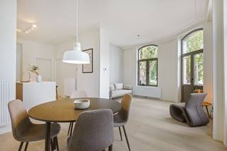 In een kleinschalig historisch hoekgebouw, dat met respect voor zijn karakter volledig werd gerenoveerd, bevindt zich op de eerste verdieping dit bijzonder aangename en lichtrijke appartement met twee slaapkamers.<br /><br />Bij het binnenkomen vallen meteen de royale plafondhoogte, de grote raampartijen en het open karakter van de leefruimte op. Vooraan geniet het appartement van een mooi en groen uitzicht over enkele karaktervolle burgerhuizen en het plein aan de Onze-Lieve-Vrouw-Geboortekerk. De grote ramen halen het daglicht rijkelijk naar binnen en versterken het ruimtelijke gevoel. Aansluitend aan de leefruimte bevindt zich bovendien een compact maar charmant sierterras.<br /><br />De open keuken vormt één geheel met de leefruimte en werd ingericht met een centraal eiland en alle nodige toestellen. Doorheen nagenoeg het volledige appartement werd een mooie parketvloer gelegd, met uitzondering van de vochtige ruimtes, wat zorgt voor een warme en stijlvolle uitstraling.<br /><br />Via de nachthal bereiken we de ruime badkamer met inloopdouche, een afzonderlijk toilet en twee volwaardige slaapkamers van ca. 12,5 m² en 9 m². Beide slaapkamers bevinden zich aan de rustige zijde van de d’Urselstraat. Vanuit de nachthal is er bovendien toegang tot een aangename extra buitenruimte (+-10m²) om in alle rust van de buitenlucht te genieten.<br /><br />Ook praktisch heeft dit appartement heel wat te bieden. In de kelderverdieping beschikt het over een private kelderberging en in de gemeenschappelijke inkomhal is een fietsenberging voorzien.<br /><br />Een bijzonder geslaagd appartement waar historische charme, licht, ruimte en hedendaags wooncomfort mooi samenkomen.<br />Bovendien superenergiezuinig: EPC label A = 42kwh/m²! alsook conforme elektriciteit én individuele zonnepanelen.<br /><br />Heeft u interesse in deze woning? Neem dan contact met het kantoor van VB Vastgoed Hoboken op het nummer 03 337 50 70 of via <span>info@vbvastgoed.be</span><br /> 