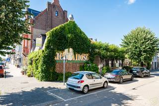 Droom je van een karaktervolle woning in het hart van Eeklo? Zoek je als ondernemer, kunstenaar of vrije beroeper een plek waar wonen en werken perfect samengaan? Of wil je gewoon veel ruimte, authenticiteit en mogelijkheden onder één dak?<br /><br />Dan moet je dit bijzondere hoekpand absoluut ontdekken.<br /><br />Achter deze gevel schuilt een verrassend ruime woning vol karakter, licht en geschiedenis. Ooit was dit een geliefde ontmoetingsplek voor Eeklonaars.<br /><br />Vandaag biedt het pand een zeldzame combinatie van gezellige woonruimtes, inspirerende werkplekken, authentieke elementen en een zonnige stadstuin. Een plek waar gezinnen kunnen groeien, ondernemers kunnen creëren en nieuwe verhalen kunnen ontstaan.<br /><br />Op wandelafstand van de Markt, De Herbakker, de bibliotheek, de kunstacademie, winkels en horeca geniet je bovendien van een toplocatie in het culturele hart van Eeklo.<br /><br /><strong>Gelijkvloers: verrassend ruim en vol karakter</strong><br />Via de voordeur aan de Molenstraat kom je binnen in een praktische inkomhal met ruime berging. Van daaruit stap je de gezellige leefkeuken binnen, voorzien van een ontbijthoek waar het heerlijk vertoeven is. Achter de keuken bevindt zich een handige tussenruimte die perfect dienst doet als extra opbergruimte en toegang biedt tot een droge, oude kelder.<br /><br />De keuken leidt vervolgens naar een sfeervolle woonkamer met pelletkachel, authentieke glas-in-loodramen en een prachtige open balkstructuur. Aansluitend bevindt zich de recent gebouwde veranda, een heerlijke plek waar je het hele jaar door kunt genieten van het uitzicht op de zonnige, fraai aangelegde binnentuin.<br /><br />Verderop vind je een smaakvol ingerichte badkamer en apart toilet.<br /><br />Een lange, lichte ruimte met meerdere lichtkoepels vormt één van de absolute blikvangers van de woning. Dankzij de overvloed aan natuurlijk licht kan deze ruimte perfect ingericht worden als eetkamer, extra salon, bibliotheek, atelier, praktijkruimte of kantoor. De mogelijkheden zijn eindeloos. Wie het verleden van het pand kent, herkent hier nog de plaats waar vroeger de authentieke cafétoog stond.<br /><br /><strong>Een tweede vleugel met tal van mogelijkheden</strong><br /><br />Deze ruimte brengt je naar de inkomhal aan de zijde van de Pastoor De Nevestraat. Ook hier beschik je over een aparte toegang, wat extra mogelijkheden creëert voor wie wonen en werken wil combineren.<br /><br />Vanuit deze hal bereik je een polyvalente bovenruimte die ideaal is als bureau, hobbyruimte, atelier, praktijkruimte, speelkamer of mancave.<br /><br />Daarnaast bevindt zich hier een bijzonder ruime slaapkamer met aansluitende dressing. Ooit vormde deze ruimte de gezellige horecazaal van het voormalige café, compleet met podium voor optredens en ontmoetingen.<br /><br />Vandaag geniet je er van veel ruimte, grote raampartijen en een aangenaam uitzicht op de straatzijde.<br /><br /><strong>Een gezellige bovenverdieping</strong><br />Via de trap in de keuken bereik je het oudste gedeelte van de woning.<br /><br />Hier bevinden zich drie charmante slaapkamers met zichtbare balkstructuren, een tweede badkamer en een handige bergruimte.<br /><br />Vanuit deze bergruimte krijg je toegang tot een ruime, droge zolder die nog heel wat extra mogelijkheden biedt voor opslag of verdere inrichting.<br /><br />Waarom dit pand zo bijzonder is<br />✅ Karaktervol pand met rijke geschiedenis<br />✅ Uitzonderlijk veel bruikbare ruimte<br />✅ Mogelijkheid tot combinatie van wonen en werken<br />✅ Ideaal voor vrije beroepen, creatieve ondernemers of grote gezinnen<br />✅ Authentieke elementen zoals glas-in-loodramen en balkenstructuren<br />✅ Zonnige binnentuin en recente veranda<br />✅ Centrale ligging in het culturele hart van Eeklo<br />✅ Meerdere toegangen en flexibele indeling<br /><br />Schrijf jij het volgende hoofdstuk?<br /><br />Dit is geen doorsnee woning. Het is een plek met een verhaal.<br /><br />Een voormalig café, ontmoetingsplek en stukje Eeklose geschiedenis dat klaar is voor een nieuwe toekomst.<br />Of je hier nu je gezinswoning, praktijk, atelier of creatieve ondernemersstek van maakt: dit pand biedt ruimte om je eigen dromen vorm te geven.<br /><br />Kom langs en ontdek zelf het uitzonderlijke potentieel van deze unieke eigendom.