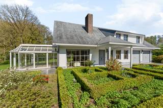 Charmante villa met ruime uitbreidingsmogelijkheden op een uniek privé-domein grenzend aan natuurgebied te Schilde<br /><br />In één van de meest gegeerde en residentiële buurten van Schilde, discreet gelegen aan het einde van een doodlopende straat, bevindt zich deze karaktervolle villa op een perceel van 4968m². Een locatie waar rust, privacy, natuurbeleving en comfort naadloos samenkomen.<br /><br />Indeling gelijkvloers:<br />De villa verwelkomt u via een ruime en lichtrijke inkomhal met vestiaire en gastentoilet. Vanuit hier bereikt u de aangename leefruimte met open haard en grote raampartijen, die zorgen voor een prachtig uitzicht op de fraai aangelegde tuin. Aansluitend bevindt zich een sfeervolle leefveranda, volledig omringd door schuiframen en voorzien van automatische zonnescreens, zodat u het hele jaar door geniet van een maximale lichtinval en een harmonieus zicht op het groen.<br /><br />De volledig uitgeruste keuken biedt eveneens zicht op en directe toegang tot het terras en wordt vergezeld door een praktische berging. Aansluitend bevindt zich een tweede gezellige leef- en eetruimte, voorzien van een houtkachel, wat deze ruimte bijzonder warm en uitnodigend maakt. Tevens is er een aparte bureauruimte, ideaal voor wie praktijk- of kantooractiviteiten aan huis wenst. De inpandige garage met automatische poort biedt plaats aan twee voertuigen.<br /><br />Eerste verdieping:<br />De nachthal leidt naar de master bedroom met ensuite badkamer, aangevuld met drie comfortabele, volwaardige slaapkamers. Daarnaast is er een tweede badkamer met douche en een bijzonder ruime, functionele wasplaats.<br /><br />Tuin en buitenbeleving:<br />De zuidwest-georiënteerde tuin vormt een ware oase van rust, met weidse vergezichten en een bijzonder harmonieuze groenbeleving. De tuin werd smaakvol aangelegd.<br /><br />Bijzonderheden:<br />- Maximale privacy, prestigieuze ligging & ideale zonoriëntatie<br />- Renovaties: 1997 (aanbouw leefruimte) – 1999 (gedeeltelijk buitenschrijnwerk)<br />- Verwarming op aardgas (Viessmann) via radiatoren en convectoren<br />- Dubbele beglazing (hout & aluminium)<br />- Rolluiken aanwezig<br />- Videofonie & automatische toegangspoort<br />- Oprit met plaats voor ca. 6 wagens<br />- Bergzolder toegankelijk via vlizotrap