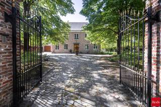 Wie op zoek is naar ruimte, rust en veelzijdigheid, voelt zich hier meteen thuis. Deze uitzonderlijke vrijstaande woning is gelegen op een prachtig perceel van maar liefst 8.392 m² en combineert royale volumes met privacy, comfort en een uniek groen kader.<br /><br />De woning wordt omgeven door een schitterende, volwassen en perfect georiënteerde zuidgerichte tuin, waar je in alle rust geniet van zon, natuur en een weids uitzicht op het omliggende groen. De ruime oprit en garage zorgen bovendien voor optimaal praktisch comfort en voldoende parkeergelegenheid.<br /><br />Binnen verwelkomt de woning je met bijzonder royale leefvolumes en een doordachte indeling. <br />De woning beschikt over 4 bijzonder ruime slaapkamers, elk met veel lichtinval en tal van indelingsmogelijkheden. De badkamer is volledig uitgerust en biedt alle comfort met zowel een ligbad als een douche.<br /><br />Een extra troef is de ruime zolderverdieping, bereikbaar via een vaste trap. Deze polyvalente ruimte biedt nog tal van mogelijkheden en kan perfect ingericht worden als extra slaapkamers, hobbyruimte, bureau of ontspanningsruimte.<br /><br />De inpandige dubbele garage heeft nog een bijkomende zolder die ook nog volledig ingericht kan worden. <br /><br />Naast het hoofdgebouw is er nog een bijgebouw dat volledig voorzien is van keuken en badkamer en mogelijkheid bied voor uitbreiding van 1 naar 3 slaapkamers. <br /><br />Dit eigendom biedt een uitzonderlijke flexibiliteit en is ze uitermate geschikt voor cohousing, kangoeroewonen, een praktijk aan huis of het comfortabel samenwonen van meerdere generaties.<br /><br />Daarnaast biedt deze woning ook energetisch nog interessante opportuniteiten: met een beperkte investering kan het EPC aanzienlijk verbeterd worden. Bij de plaatsing van een warmtepomp en het verwijderen van de houtkachel kan de EPC-score stijgen naar begin label B, wat een mooie meerwaarde betekent voor de toekomstige eigenaar.<br /><br />Contacteer Vincent voor een bezoek ter plaatse via 0475 21 00 86 of Vincent@reds.be.