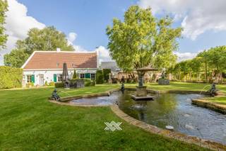 Verscholen tussen het groen, met liefst 110 meter oever langs het water, bevindt zich dit rustig gelegen landhuis met bedrijfsgebouw in Lievegem...